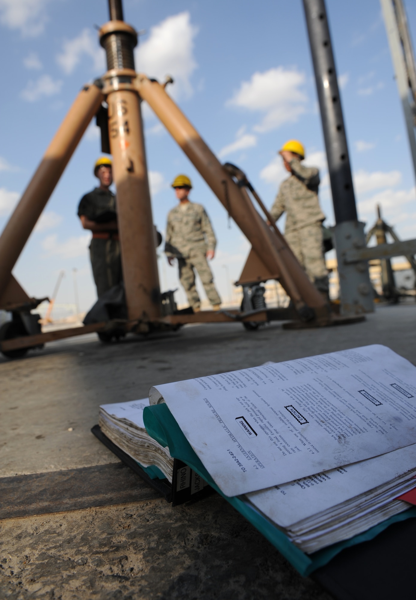 SOUTHWEST ASIA – With his technical order for a 60-ton tripod jack open, Staff Sgt. Brian Van Stee, 379th Expeditionary Maintenance Squadron aerospace ground equipment (AGE) mechanic and native of Cheyenne, Wyo., discusses maintenance procedures with leadership from the 379th Air Expeditionary Wing here Dec. 21, 2011. Every piece of equipment the 379th EMXS AGE Flight services is accompanied by a technical order, which provides step-by-step procedures for all types of maintenance. Van Stee is deployed from Robins Air Force Base, Ga. (U.S. Air Force photo/Staff Sgt. Nathanael Callon)
