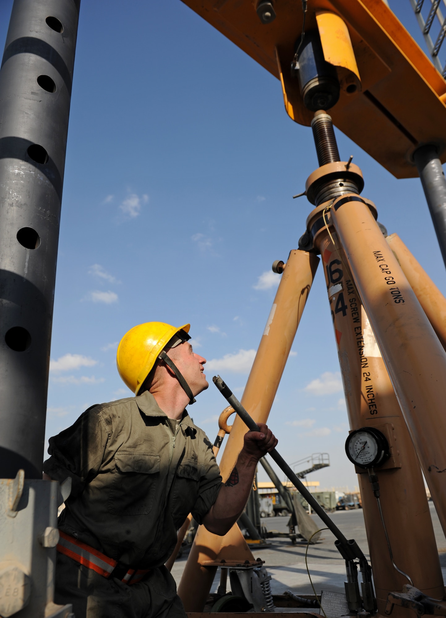 SOUTHWEST ASIA – Staff Sgt. Brian Van Stee, 379th Expeditionary Maintenance Squadron aerospace ground equipment (AGE) mechanic and native of Cheyenne, Wyo., manually pumps a 60-ton tripod jack to test its ability to hold weight during routine maintenance here Dec. 21, 2011. The 60-ton tripod jack is used on the flightline to lift aircraft during maintenance. The 379th EMXS AGE Flight keeps test equipment, tow vehicles, bomb jammers, electronic circuitry and other aircraft support equipment working. The flight maintains 638 pieces of equipment across the base. Van Stee is deployed from Robins Air Force Base, Ga. (U.S. Air Force photo/Staff Sgt. Nathanael Callon)