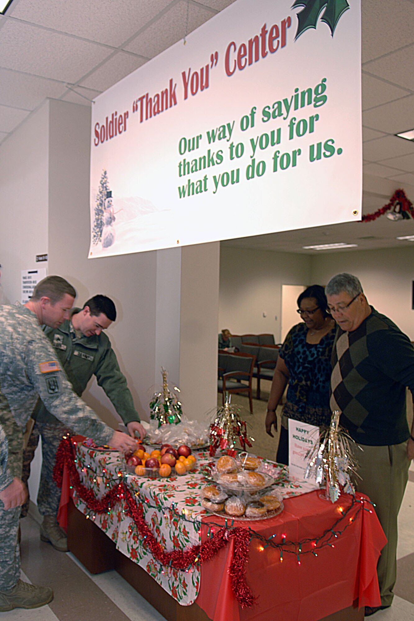 Soldiers take free snacks from the “Soldier ‘Thank You’ Center” table Dec. 15 at the Fort  Eustis 733rd Mission Support Group Soldier Support Center. Lani Gates of the Military Personnel Branch of the SSC came up with the idea for the “Soldier ‘Thank You’ Center” and all the staff at the SSC pitched in as a way of thanking servicemembers during the holiday season for all they do for their country. (U.S. Air Force photo by Staff Sgt. Jeff Nevison/Released)