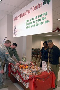 Soldiers take free snacks from the “Soldier ‘Thank You’ Center” table Dec. 15 at the Fort  Eustis 733rd Mission Support Group Soldier Support Center. Lani Gates of the Military Personnel Branch of the SSC came up with the idea for the “Soldier ‘Thank You’ Center” and all the staff at the SSC pitched in as a way of thanking servicemembers during the holiday season for all they do for their country. (U.S. Air Force photo by Staff Sgt. Jeff Nevison/Released)