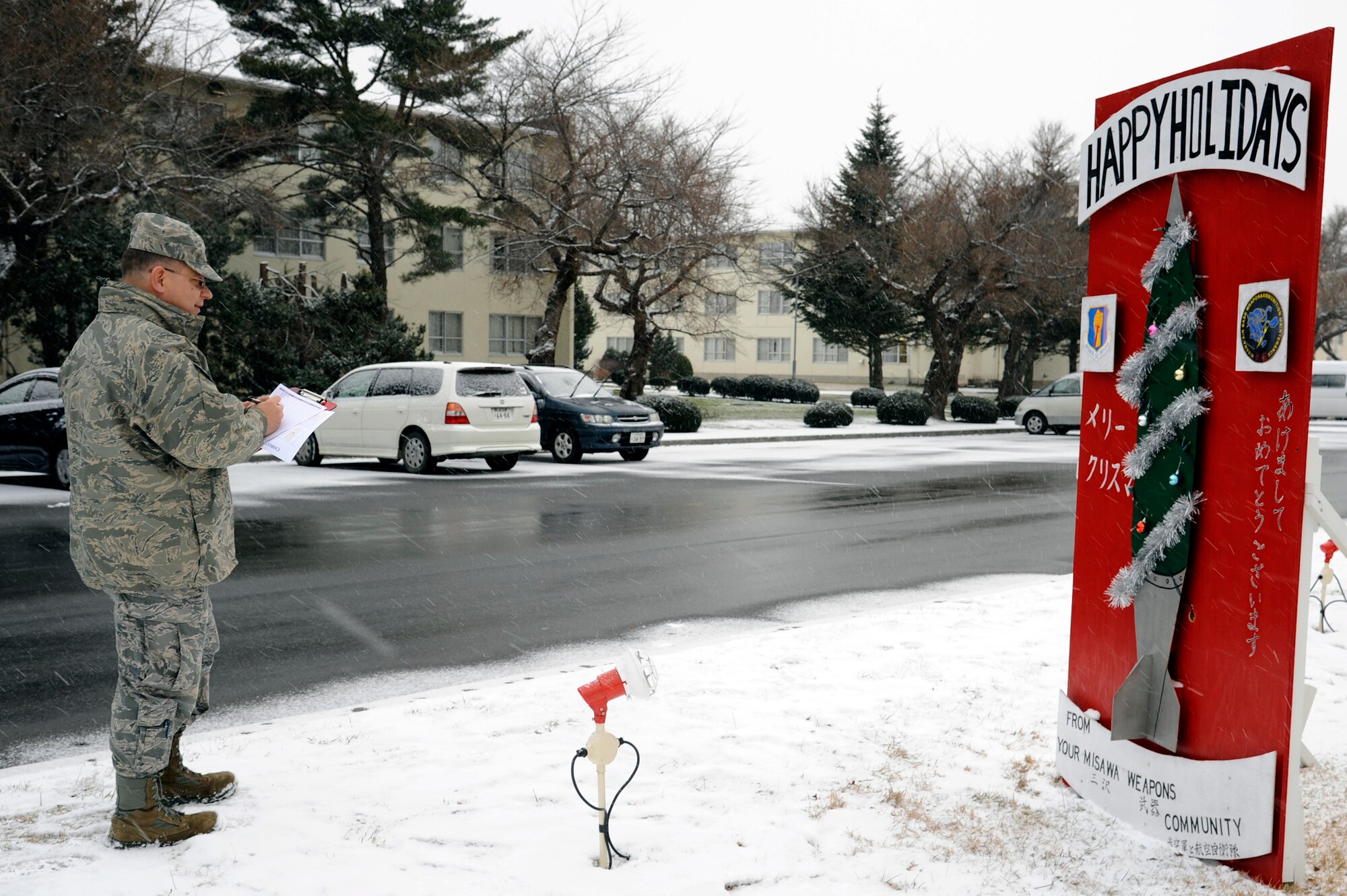 MISAWA AIR BASE, Japan - Col. John Griffin, 35th Mission Support Group commander, judges one of the many holiday greeting cards on display along Risner Circle here, Dec. 16. Thirty-three giant holiday greeting cards were decorated by Misawa Air Base units and private organizations. (U.S. Air Force photo/Tech. Sgt. Marie Brown)