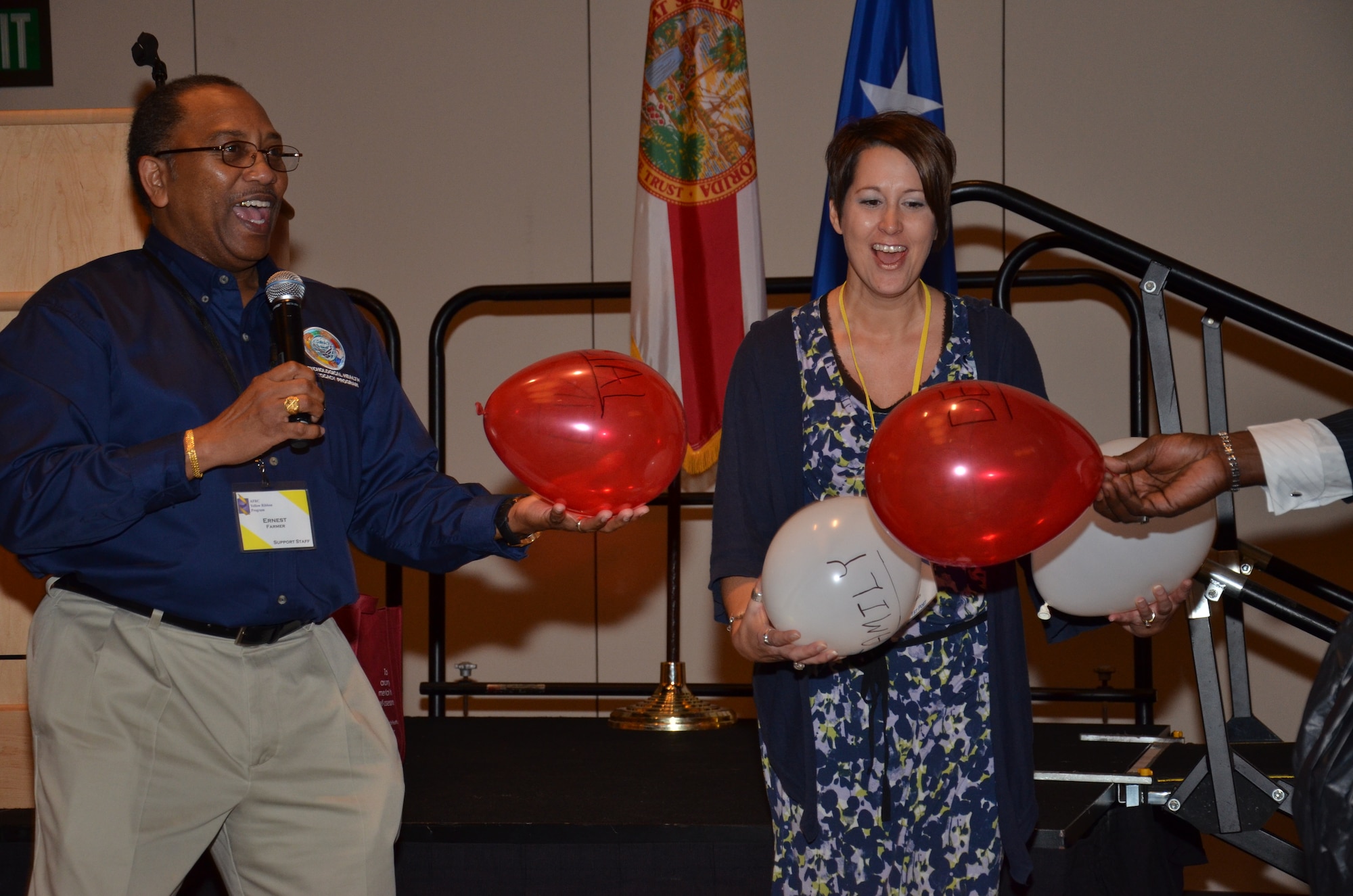 An Air Force Psychological Health Advocacy Program representative uses an audience member and balloons to help demonstrate the difficulties Reservists have juggling different aspects of their lives at an Air Force Reserve Command Yellow Ribbon Event in Orlando, Fla., Dec. 17, 2011. PHAP services were available for pre- and post-deployment Reservists and family members to speak with and seek guidance over the course of the weekend event. (U.S. Air Force photo/Staff Sgt. Anna-Marie Wyant)