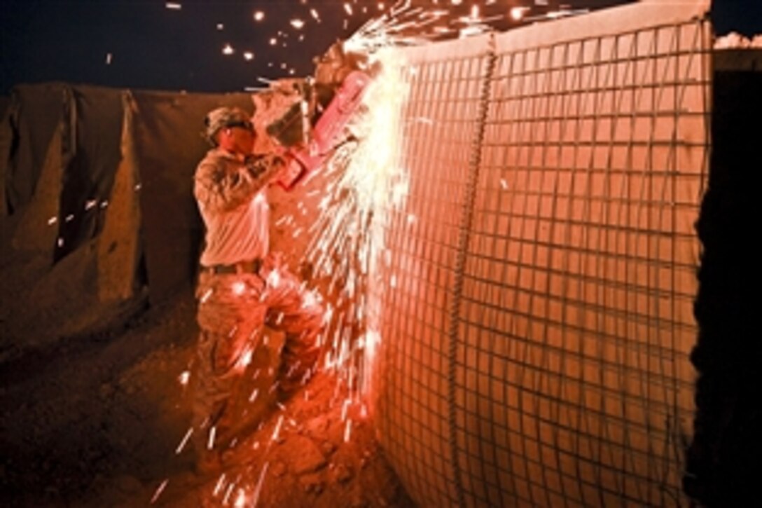U.S. Marine Corps Cpl. James Hernandez uses an electric saw to dismantle a HESCO barrier on Firebase Saenz in Afghanistan's Helmand province, Dec. 13, 2011. Hernandez is a combat engineer assigned to Alpha Company, 9th Engineer Support Battalion. The firebase is the first of several patrol bases being demilitarized by the Marines.