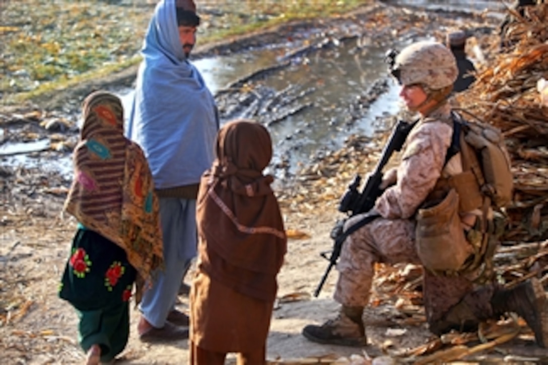 U.S. Marine Corps Cpl. Brandy Bates stops to talk with Afghan children during a foot patrol through Tughay village in the Sangin district of Afghanistan's Helmand province on Dec. 6, 2011.  