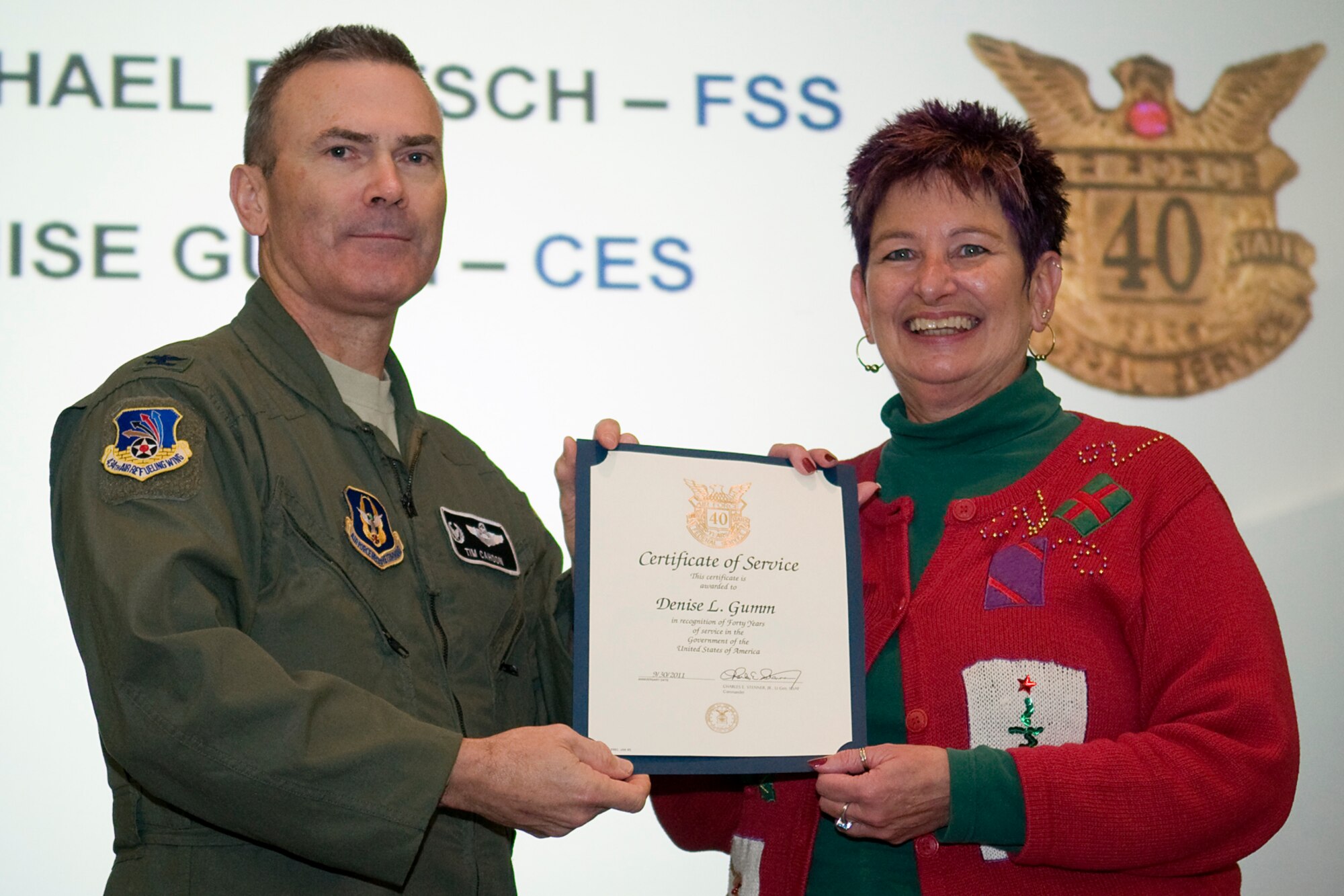 GRISSOM AIR RESERVE BASE, Ind. -- Col. William T. "Tim" Cahoon, 434th Air Refueling Wing commander, presents Denise Gumm with a certificate and pin recognizing her for 40 years of federal civil service at a recent civilian commander's call here. Gumm is a chief of real property with the 434th Civil Engineer Squadron. (U.S. Air Force photo/Tech. Sgt. Mark R. W. Orders-Woempner)