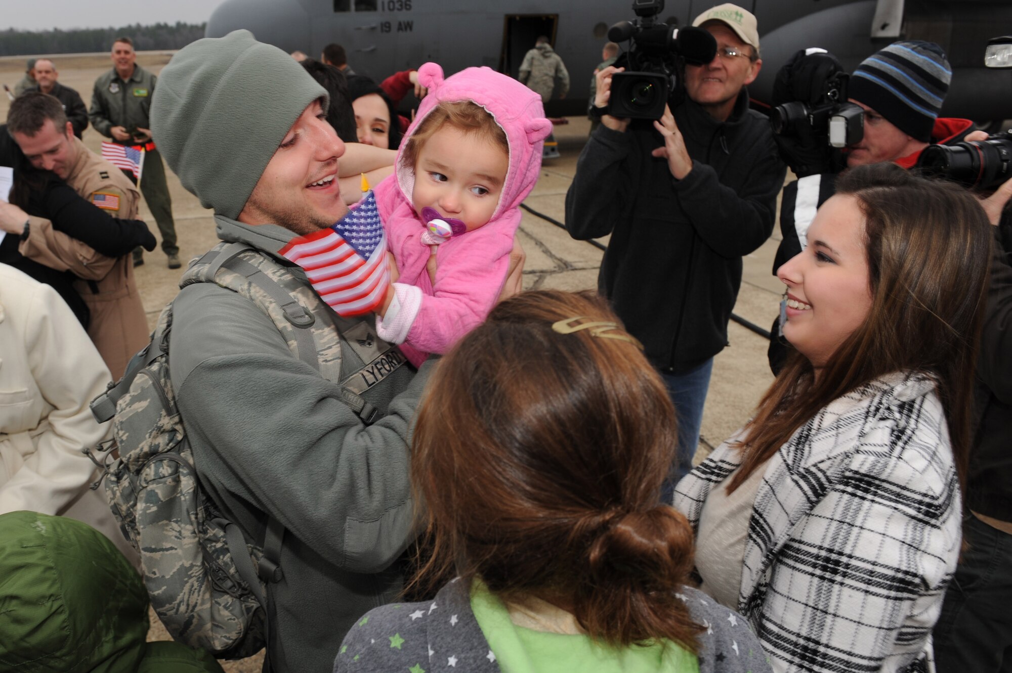 Senior Airman Joshua Lyford, a 19th Aircraft Maintenance Squadron communication navigation mission systems journeyman, hugs his 18-month-old daughter, Kaylee, as his wife Amber, (right), and sister-in-law, Mikayla Wright, also greet him Dec. 23, at Little Rock Air Force Base. Lyford is returning home from a deployment supporting operations in Southwest Asia just days before the holidays. (U.S. Air Force photo by Tech. Sgt. Chad Chisholm)