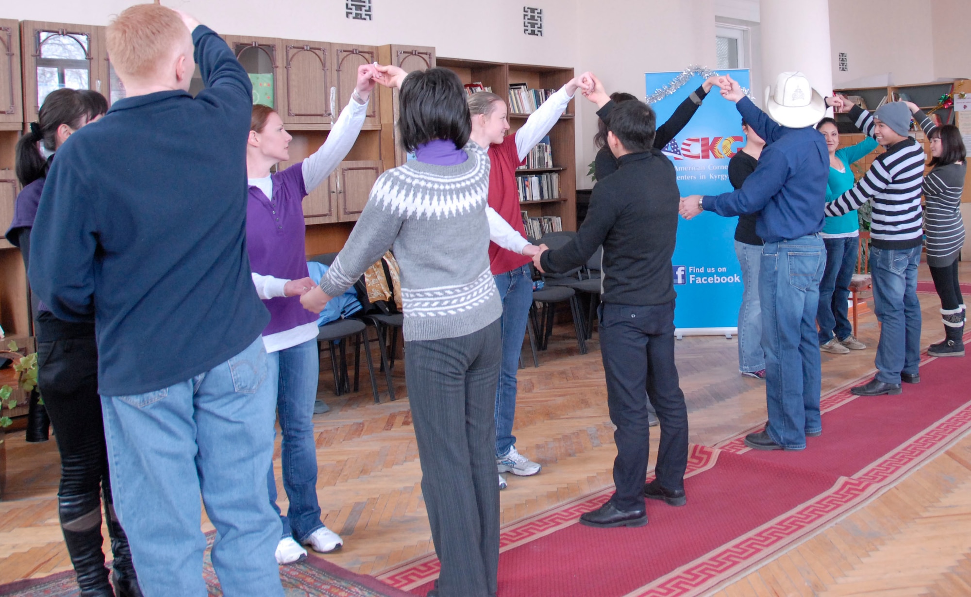 TRANSIT CENTER AT MANAS, Kyrgyzstan -- Airmen deployed to the Transit Center at Manas interact with Kyrgyz students by demonstrating country swing dance Dec. 20, 2011 during a visit to Bayalinov Library . The Airmen are part of a cultural exchange project called "American Corner." The group travels to local areas to teach the population about the American culture and to learn about Kyrgyz culture as well. (U.S. Air Force photo/ Senior Airman Lynsie Nichols)
