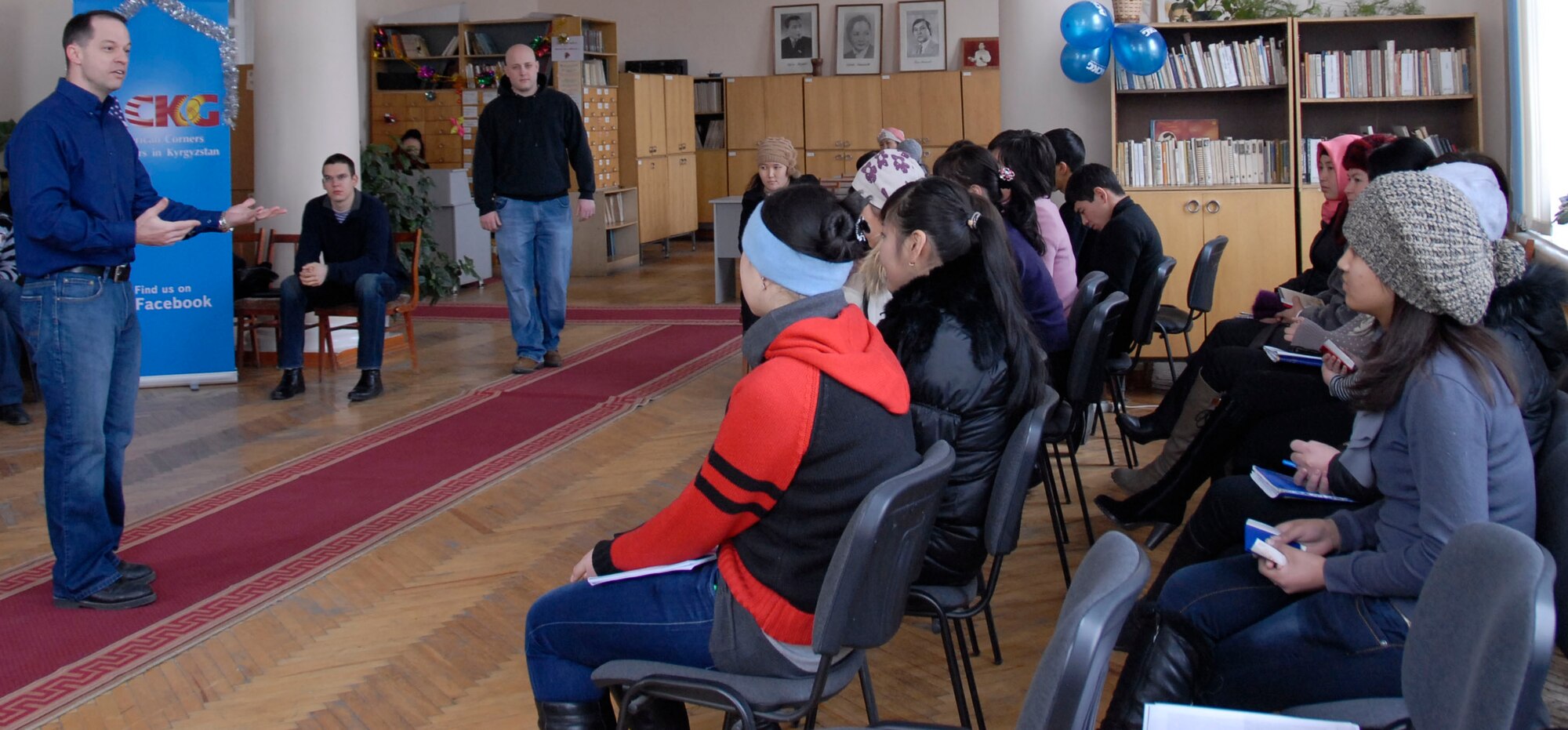 TRANSIT CENTER AT MANAS, Kyrgyzstan -- Capt. Stephen Martin, the Theater Security Cooperation humanitarian assistance medical director, talks to a group of Kyrgyz students about country swing dance Dec. 20, 2011 during a visit to Bayalinov Library. Martin and other Transit Center Airmen are part of a cultural exchange project called "American Corner." The group travels to local areas to teach the population about the American culture and to learn about Kyrgyz culture as well. Martin is deployed from Davis-Monthan Air Force Base, Ariz. (U.S. Air Force photo/ Senior Airman Lynsie Nichols)