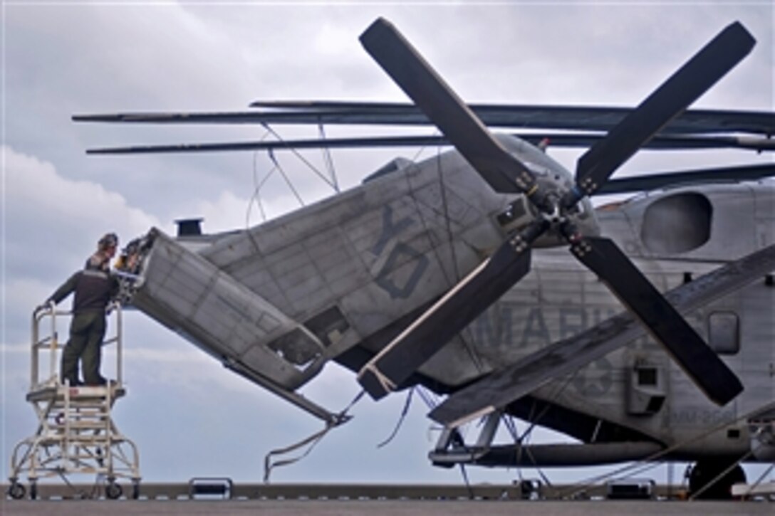 U.S. Marines perform maintenance on a CH-53E Super Stallion aboard the USS Makin Island (LHD 8) underway in the Pacific Ocean on Dec. 20, 2011.  The Makin Island is on its maiden deployment conducting operations in the U.S. 7th Fleet area of responsibility.  U.S. sailors and Marines assigned to the USS Abraham Lincoln, the USS Carl Vinson and the USS Makin Island performed several operations between Dec. 13 and Dec. 20, 2011, while underway in the Pacific Ocean.  