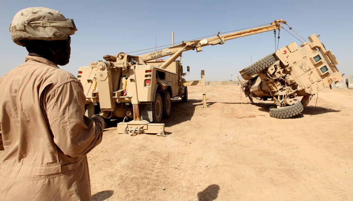 Cpl. Jean Satune, a Motor Transport wrecker operator with 2nd Maintenance Battalion, prepares a disabled vehicle to be turned upright using the new Mine Resistant Ambush Protected recovery vehicle during a training simulation on Camp Leatherneck in Helmand province, Afghanistan, April 26.  Satune, a Brooklyn, New York native, and another Marine received almost two weeks of classroom and practical application training to familiarize them with the MVR.  (U.S. Marine Corps photo by Lance Cpl. Katherine M. Solano)