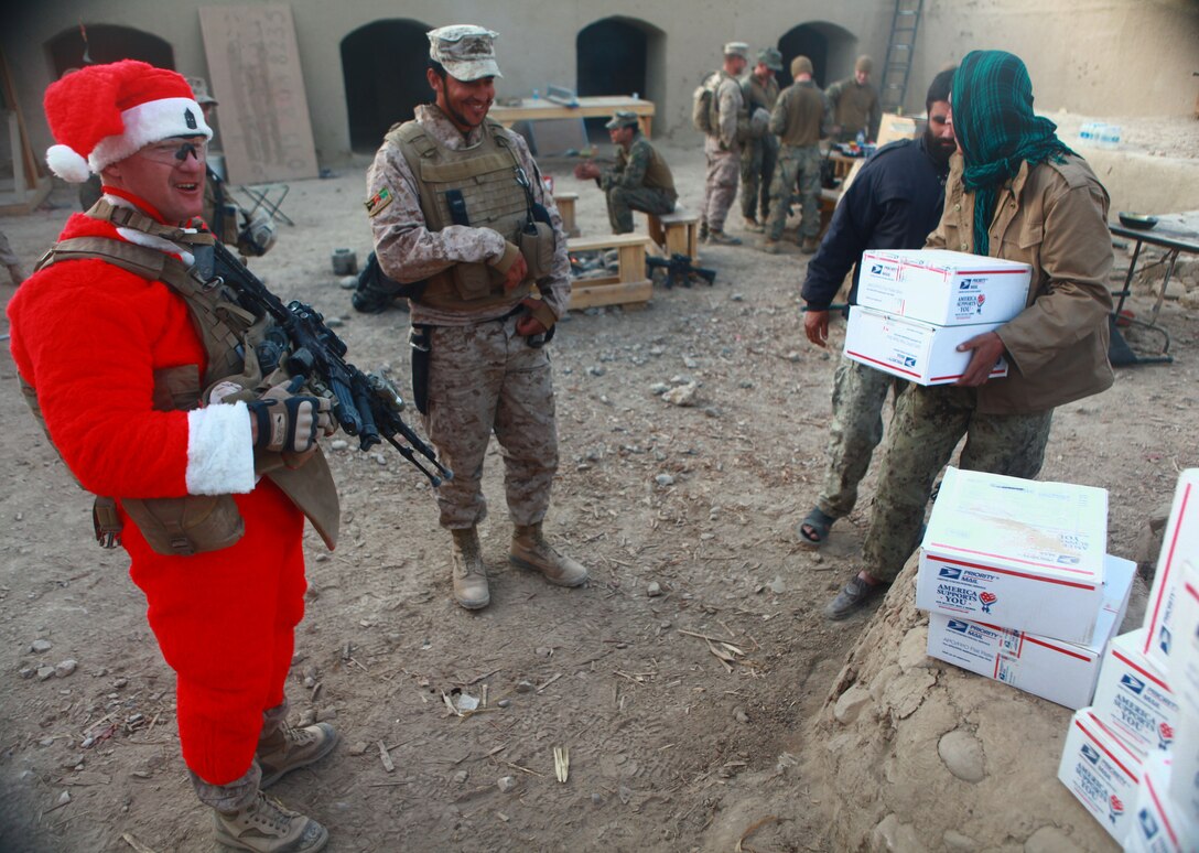 Sgt. Maj. Larry J. Harrington, battalion sergeant major, 1st Battalion, 6th Marine Regiment, gives presents to members of the Afghan Civil Order Police Force, Dec. 23. Harrington, along with the battalion commander, and members of their Personal Security Detail, visited patrol bases and observation posts across the battalion’s area of operations, bringing presents and gifts to Marines in celebration of the holiday.