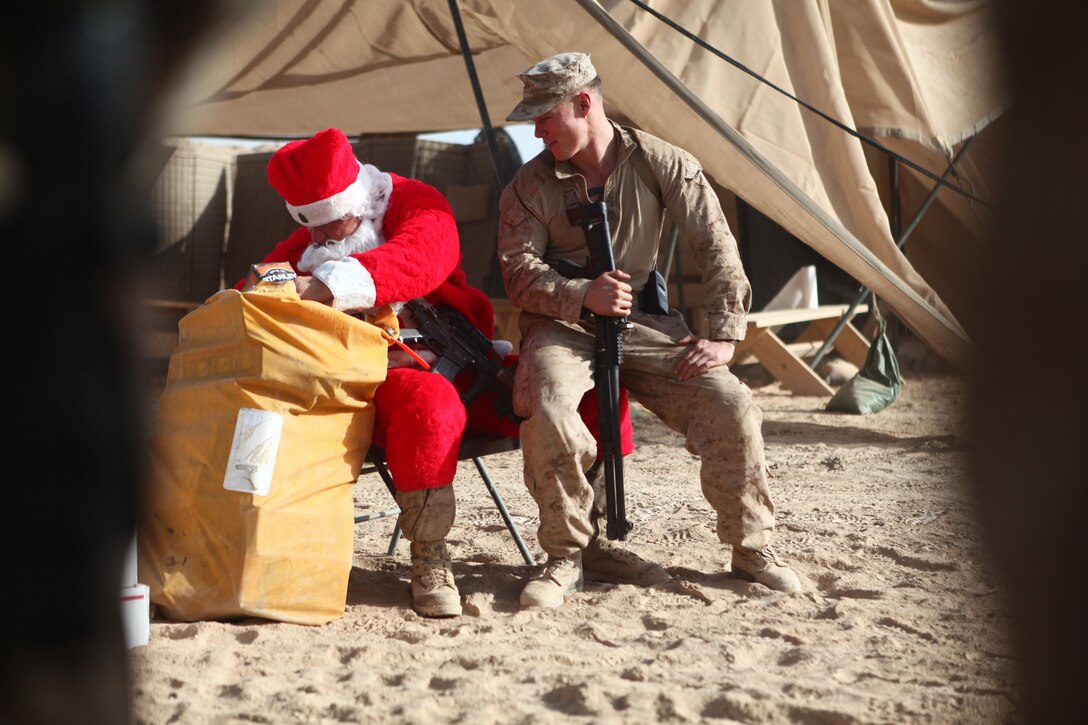Sgt. Maj. Larry J. Harrington, battalion sergeant major, 1st Battalion, 6th Marine Regiment, gives presents to a Marine with Company A, 1/6, at Patrol Base Alcatraz, Sangin District, Dec. 23. Harrington, along with the battalion commander, and members of their Personal Security Detail, visited patrol bases and observation posts across the battalion’s area of operations, bringing presents and gifts to Marines in celebration of the holiday.