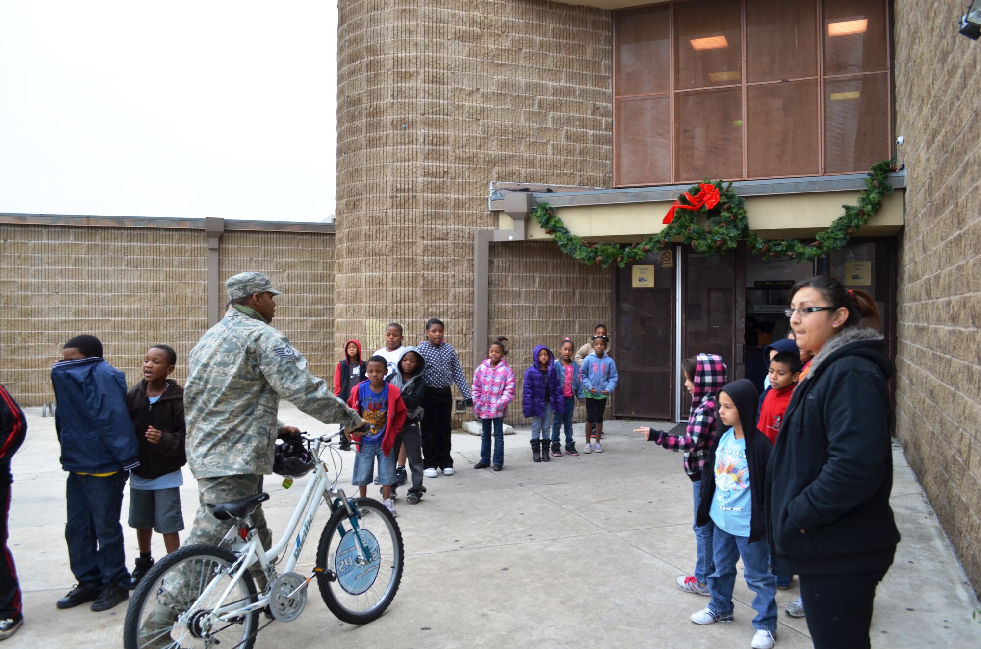Cold and excited Boys & Girls Club members brave the chilly temperatures to greet Tech Sgt. Brian Terrell,433rd Aircraft Maintenance Squadron, as he delivers one of the 63 bikes donated by the 433rd Airlift Wing. For the third consecutive year, the Alamo Wing Top Three gathered bikes and safety equipment to donate to children in need. Youth were selected on the basis of participation, behavior, and grades by Boys & Girls Club staff members from branches throughtout San Antonio, Texas. (U.S. Air Force photo/ Tech Sgt. Carlos J. Trevino)   