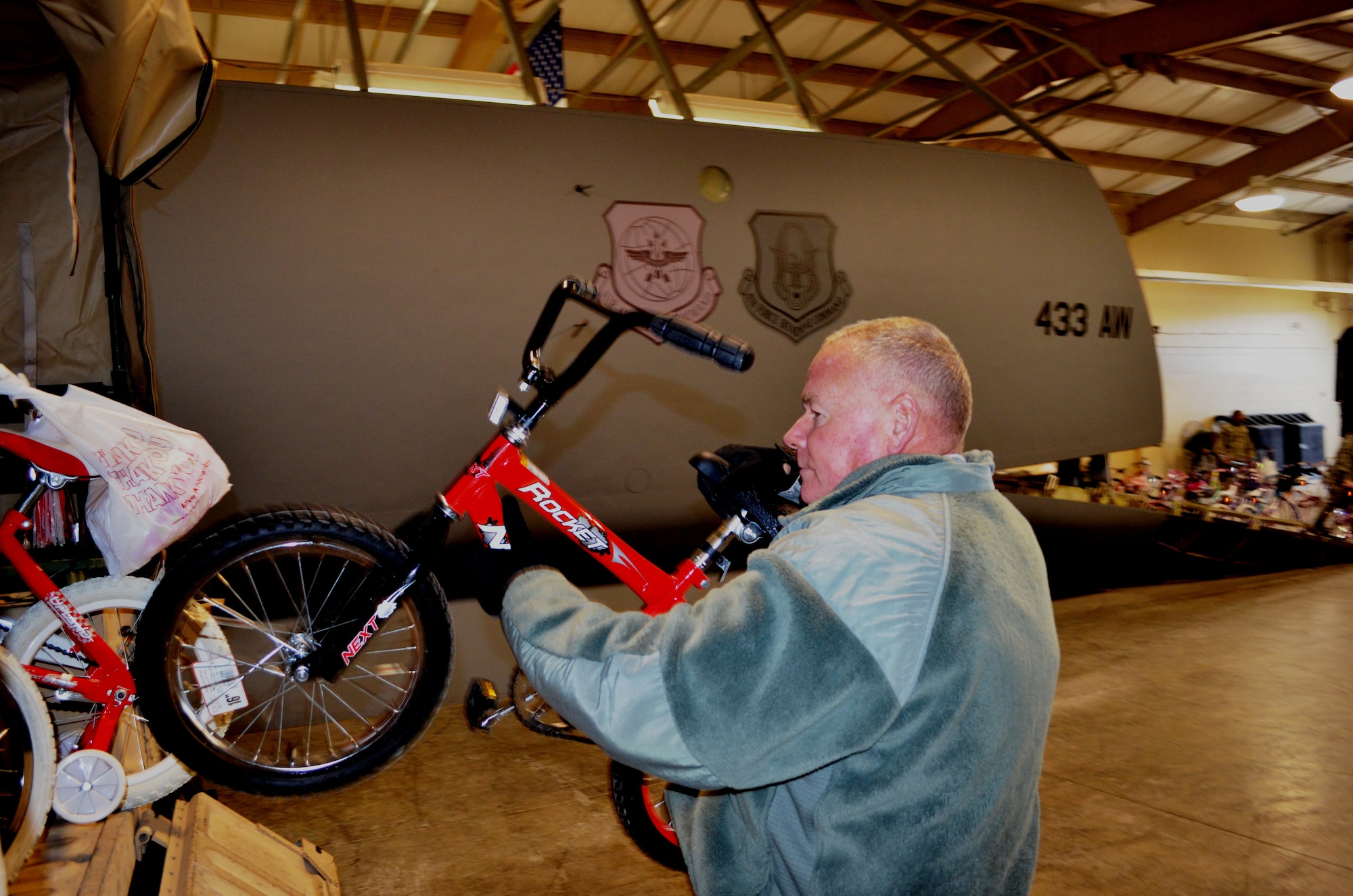 Master Sgt. Robert Kane, 433rd AMXS, loads one of the 63 bikes donated by the 433rd Airlift Wing, into a Humvee.  "There are going to be some happy kids," Kane said as he drove the Humvee into the parking lot of the Boys & Girls Club and saw the members lined up outside. For the third consecutive year, the Alamo Wing Top Three gathered bikes and safety equipment to donate to children in need. Youth were selected on the basis of participation, behavior, and grades by Boys & Girls Club staff members from branches throughtout San Antonio, Texas. (U.S. Air Force photo/ Tech Sgt. Carlos J. Trevino)  