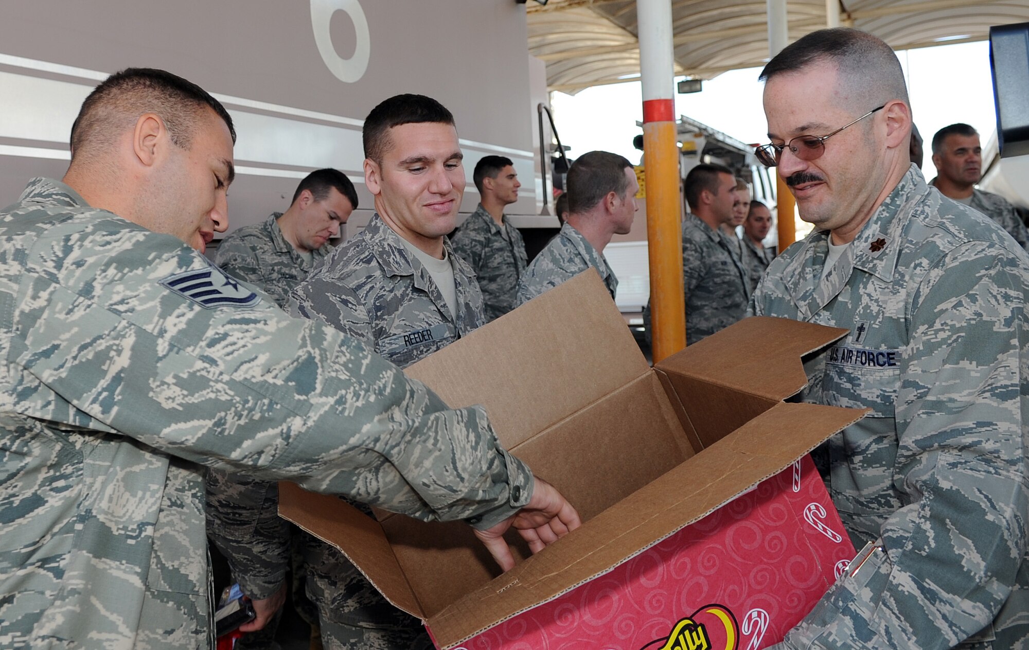 SOUTHWEST ASIA - Chaplain (Maj.) Jamie Danford passes out stockings to members of the fire department at the 380th Air Expeditionary Wing Dec. 22, 2011. Over the past several weeks, the chapel staff collected thousands of items for their Operation: Holiday Blitz. Roughly 40 volunteers helped the staff put together stockings for everyone deployed here. (U.S. Air Force photo/Staff Sgt. J.G. Buzanowski)