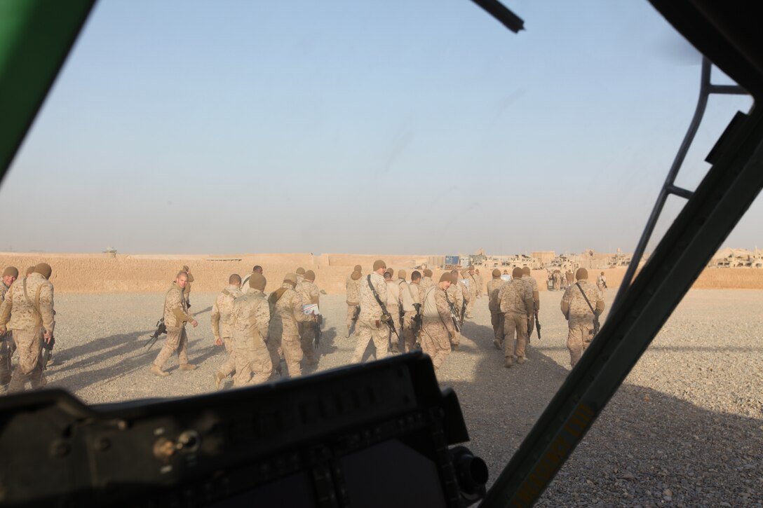 Marines at a forward operating base in Helmand province, Afghanistan, carry care packages delivered by Marine Light Attack Helicopter Squadron 369, Dec. 25. The Marine Corps helicopter squadron flew thousands of pounds of care packages to infantry Marines at austere combat outposts in Afghanistan on Christmas Day.::r::::n::::r::::n::::r::::n::