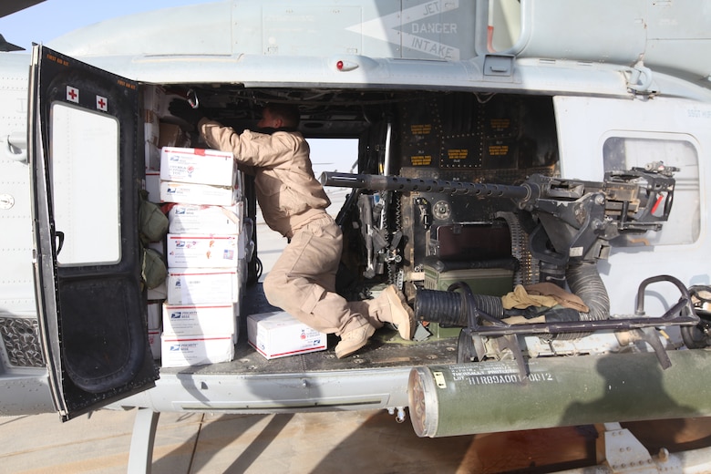 Staff Sgt. Michael Evans, a crew chief with Marine Light Attack Helicopter Squadron 369, checks care packages loaded onto a Marine Corps UH-1Y Huey at Camp Bastion, Afghanistan, Dec. 25. The Marine Corps helicopter squadron flew thousands of pounds of care packages to infantry Marines at austere combat outposts in Afghanistan on Christmas Day.::r::::n::::r::::n::::r::::n::