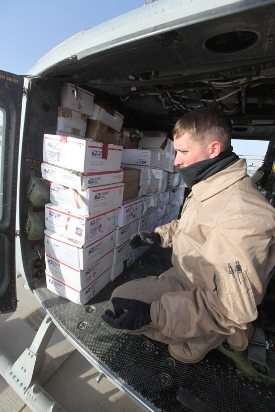 Staff Sgt. Michael Evans, a crew chief with Marine Light Attack Helicopter Squadron 369, checks care packages loaded onto a Marine Corps UH-1Y Huey at Camp Bastion, Afghanistan, Dec. 25. The Marine Corps helicopter squadron flew thousands of pounds of care packages to infantry Marines at austere combat outposts in Afghanistan on Christmas Day.::r::::n::::r::::n::::r::::n::