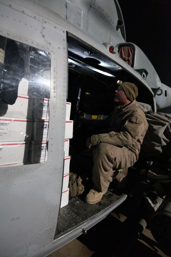 Lance Cpl. Andrew Harris, a crew chief with Marine Light Attack Helicopter Squadron 369, checks care packages loaded onto a Marine Corps UH-1Y Huey at Camp Bastion, Afghanistan, Dec. 25. The Marine Corps helicopter squadron flew thousands of pounds of care packages to infantry Marines at austere combat outposts in Afghanistan on Christmas Day.::r::::n::::r::::n::::r::::n::