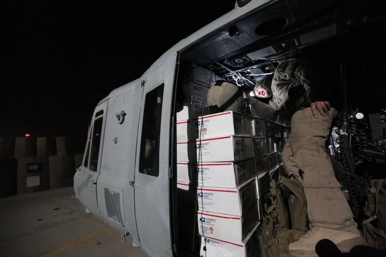 Lance Cpl. Andrew Harris, a crew chief with Marine Light Attack Helicopter Squadron 369, checks care packages loaded onto a Marine Corps UH-1Y Huey at Camp Bastion, Afghanistan, Dec. 25. The Marine Corps helicopter squadron flew thousands of pounds of care packages to infantry Marines at austere combat outposts in Afghanistan on Christmas Day.::r::::n::::r::::n::::r::::n::