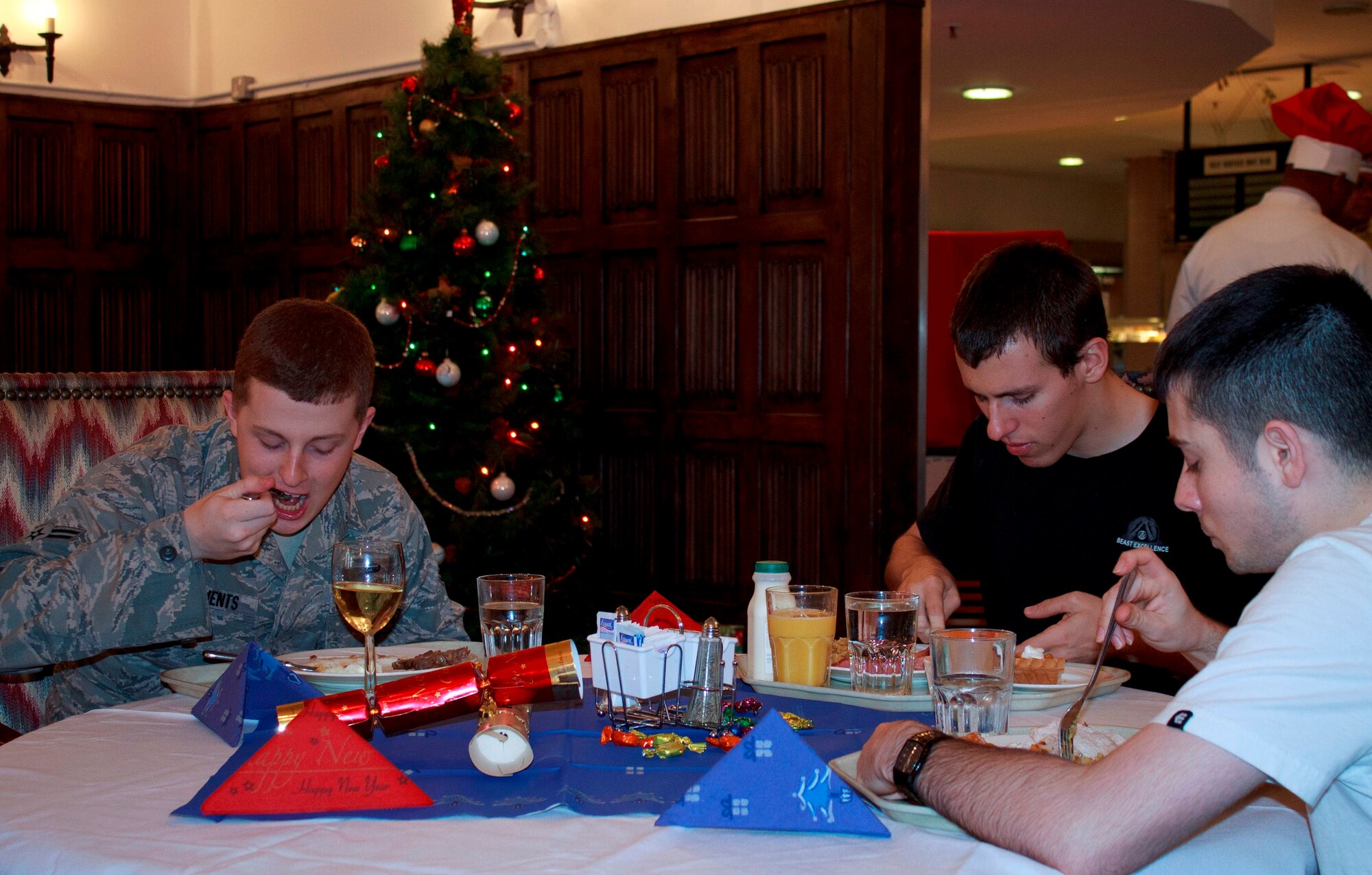 RAF MILDENHALL, England – (left to right) Airman 1st Class Carl Clements, 100th Force Support Squadron, Airman 1st Class Cameron Gnile, 100th Logistics Readiness Squadron, and Senior Airman Taylor Mogford, 100th LRS, eat a Christmas meal at the RAF Mildenhall Dining Facility here on Christmas Day. Clements and Cameron are from California, while Mogford is from Texas. All three Airmen live in the dormitories and say they don’t have any major plans for the rest of the day. (U.S. Air Force photo/1st Lt. Jason Smith)