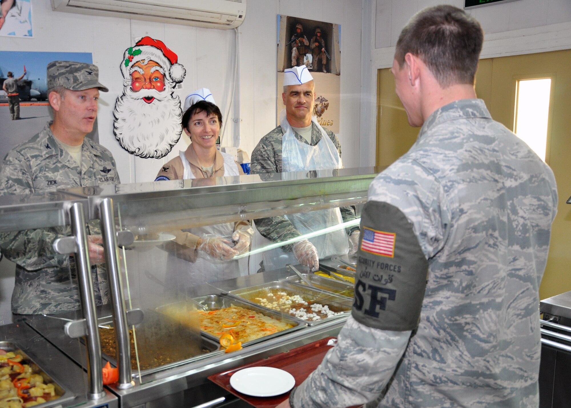 SOUTHWEST ASIA – Col. Michael Zick, 386th Air Expeditionary Wing commander, Col. Tracy Szczepaniak, Officer Military Coordination-Kuwait vice chief, and Lt. Col. Rives Duncan, 387th Air Expeditionary Group chaplain, serve Christmas lunch to members of the 387th AEG Dec. 25, 2011.  The senior leaders were thankful to be able to give back to military personnel here who make the mission happen on a daily basis. (U.S. Air Force photo/Tech. Sgt. Stacy Fowler)