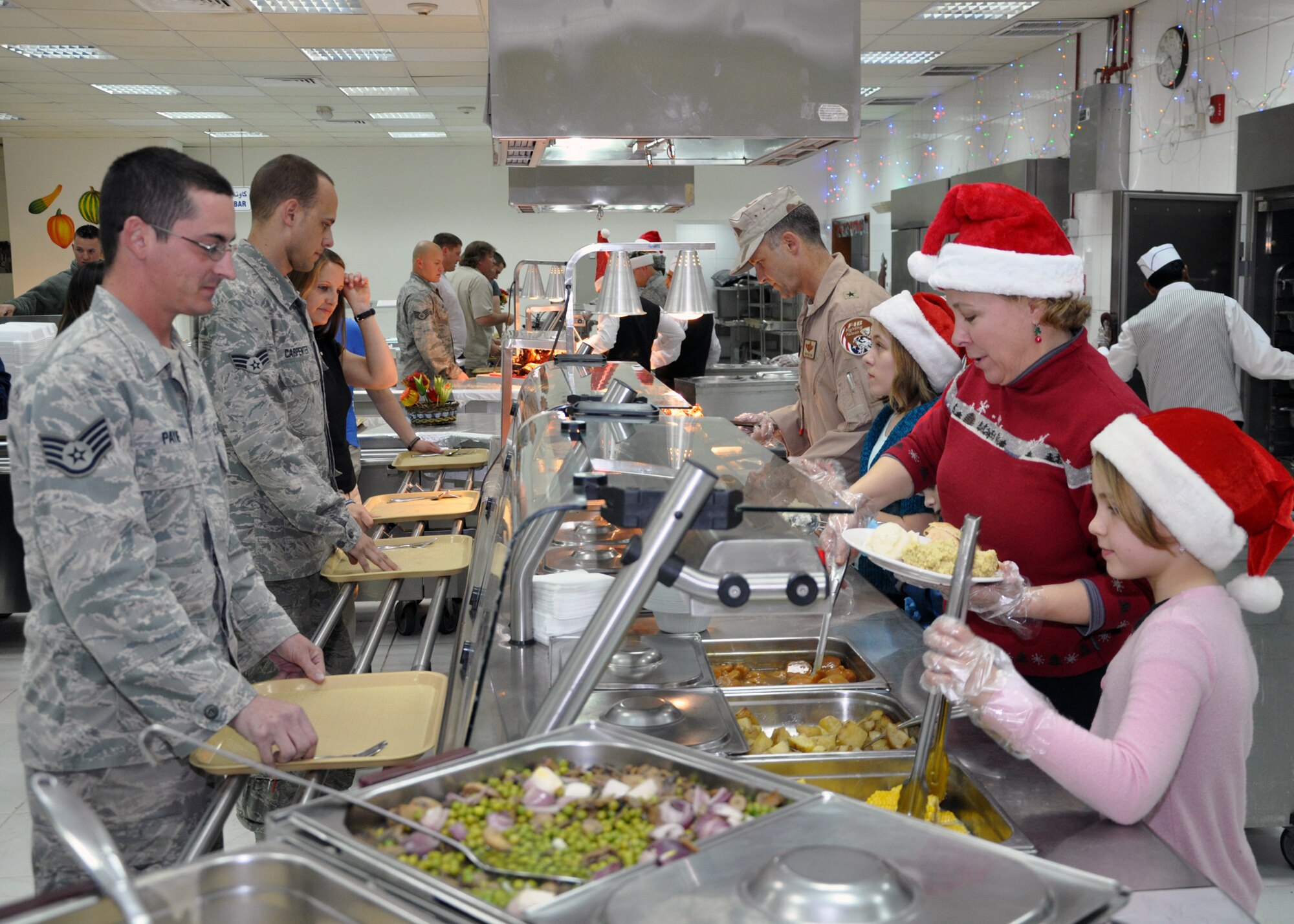 SOUTHWEST ASIA -- Brig. Gen. Rick Mattson, Officer Military Coordination-Kuwait chief, and his family serve Christmas dinner to servicemembers in the 386th Air Expeditionary Wing, Dec. 25, 2011.  The general and his family wanted to give back to all servicemembers who support operations while deployed to the area of responsibility – especially during the 2011 holiday season, when many are away from their family and friends. (U.S. Air Force photo/Tech. Sgt. Stacy Fowler)