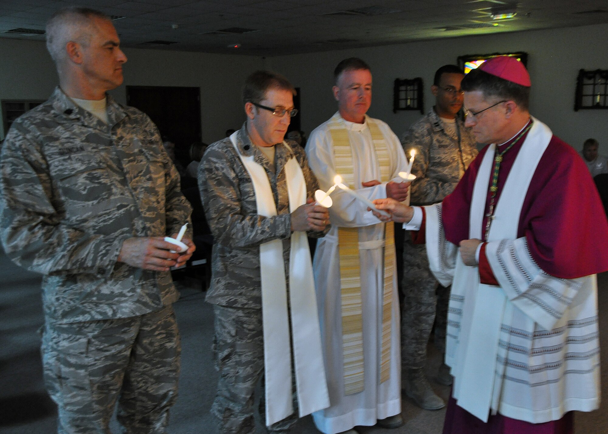 SOUTHWEST ASIA -- Archbishop Timothy Broglio (far right), Archbishop of Military Services, lights the candles of (left to right) Lt. Col. Rives Duncan, Lt. Col. David Pendleton, Lt. Col. Mark Rowan and Capt. Carlos Brito, all chaplains in the 386th Air Expeditionary Wing, during the Christmas Candlelight Service Dec. 24, 2011.  Archbishop Broglio has been visiting bases and posts around the area of responsibility, bringing spiritual comfort to those who are away from their families during the 2011 holiday season. (U.S. Air Force photo/Tech. Sgt. Stacy Fowler)
