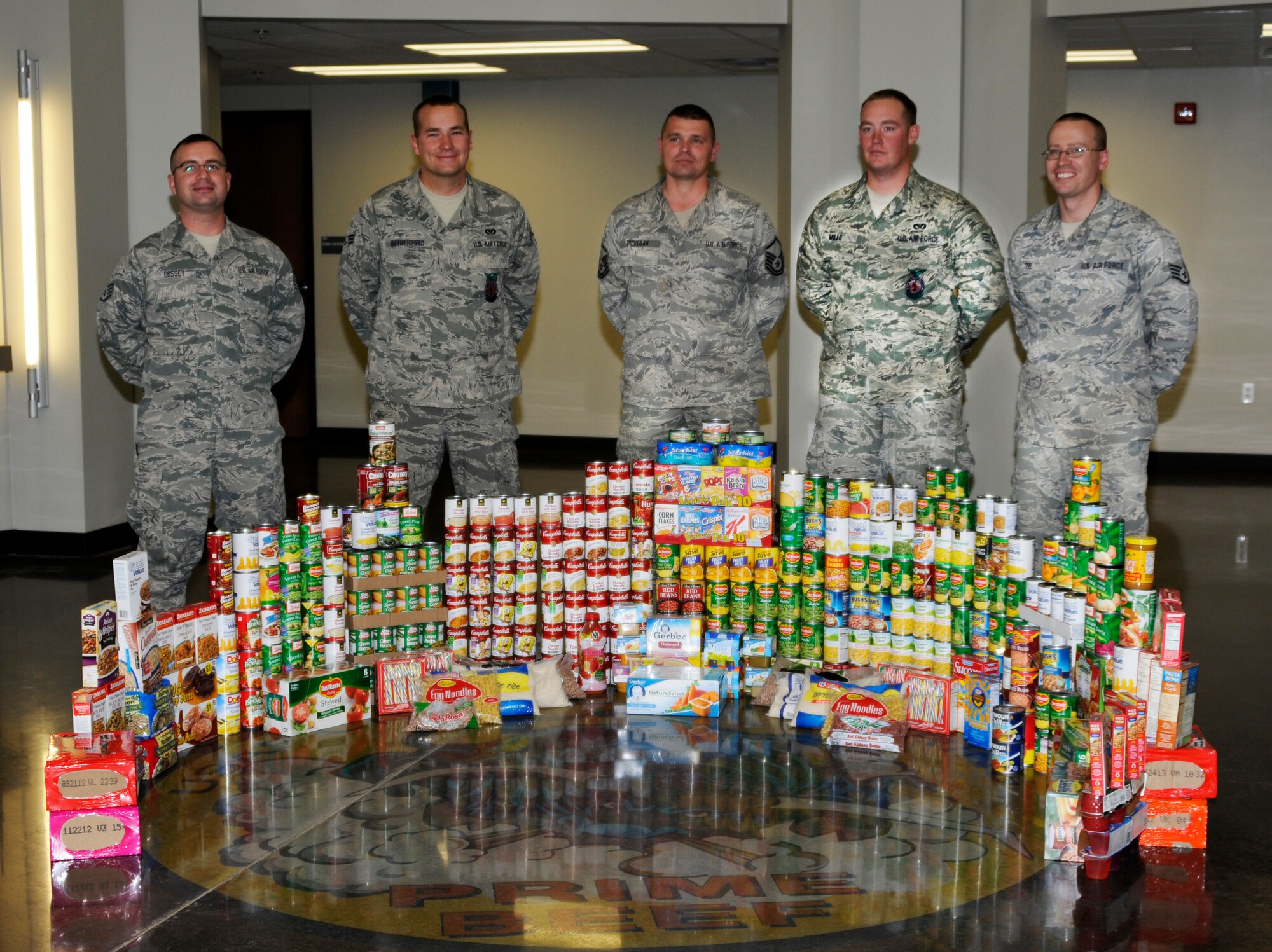 Airmen with the 188th Fighter Wing’s Civil Engineer Squadron pose for a photograph in front of a collection of nonperishable food items at the CES headquarters facility. The goods were collected as part of a food drive put on by the 188th CES. (U.S. Air Force photo by Airman 1st Class Hannah Landeros/188th Fighter Wing Public Affairs)
