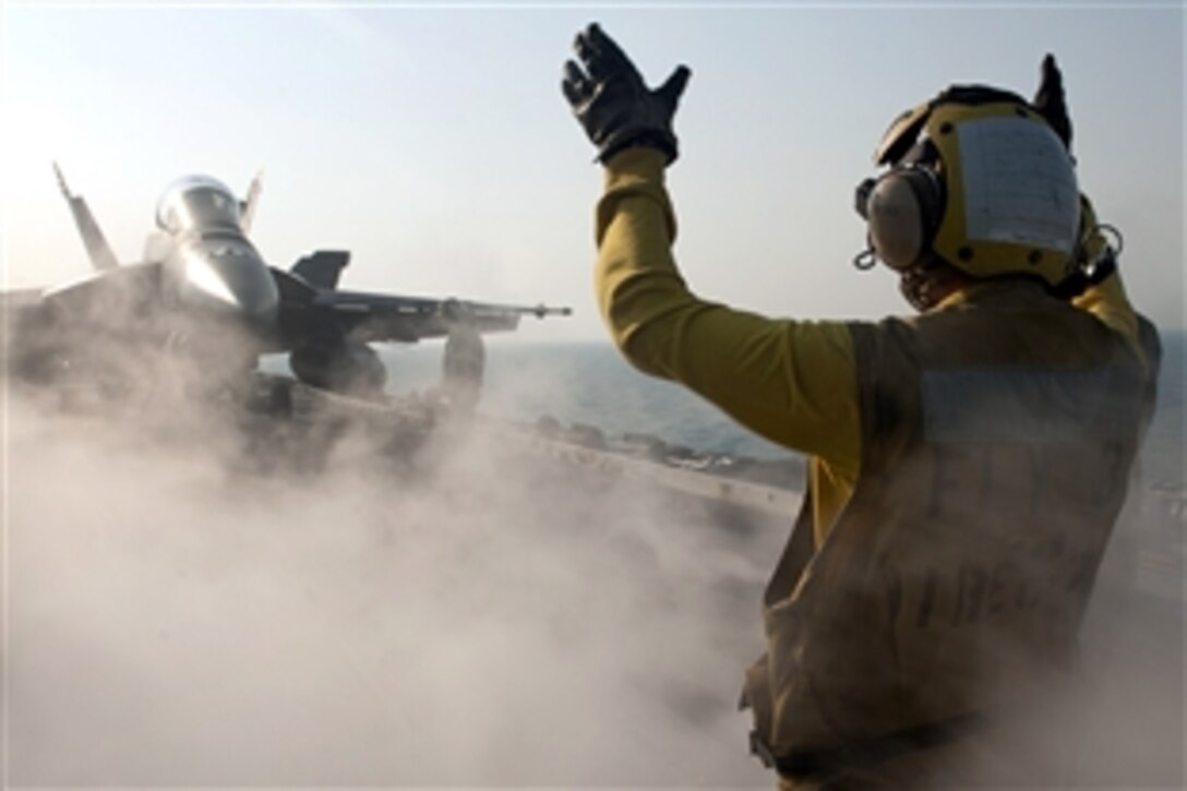 U.S. Navy Seaman Michael Linscott directs an F/A-18F Super Hornet on the flight deck of the aircraft carrier USS John C. Stennis under way in the Pacific Ocean, Dec. 18, 2011. Linscott is an aviation boatswain's mate airman. The John C. Stennis is deployed to the U.S. 5th Fleet area of responsibility conducting maritime security operations and support missions. 