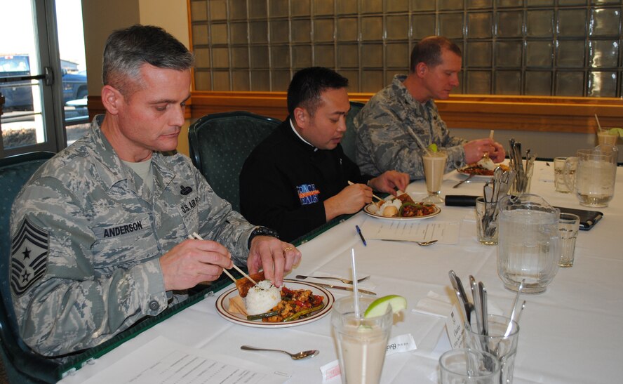 Chief Master Sgt. Charles Anderson, 341st Missile Wing command chief, Father Leo Patalinghug and Col. Robert Stanley, 341st Missile Wing vice commander, test the eventual winning dish -- apple chicken stir fry with jasmine rice and an apple egg roll. (U.S. Air Force photo/Airman 1st Class Katrina Heikkinen)

