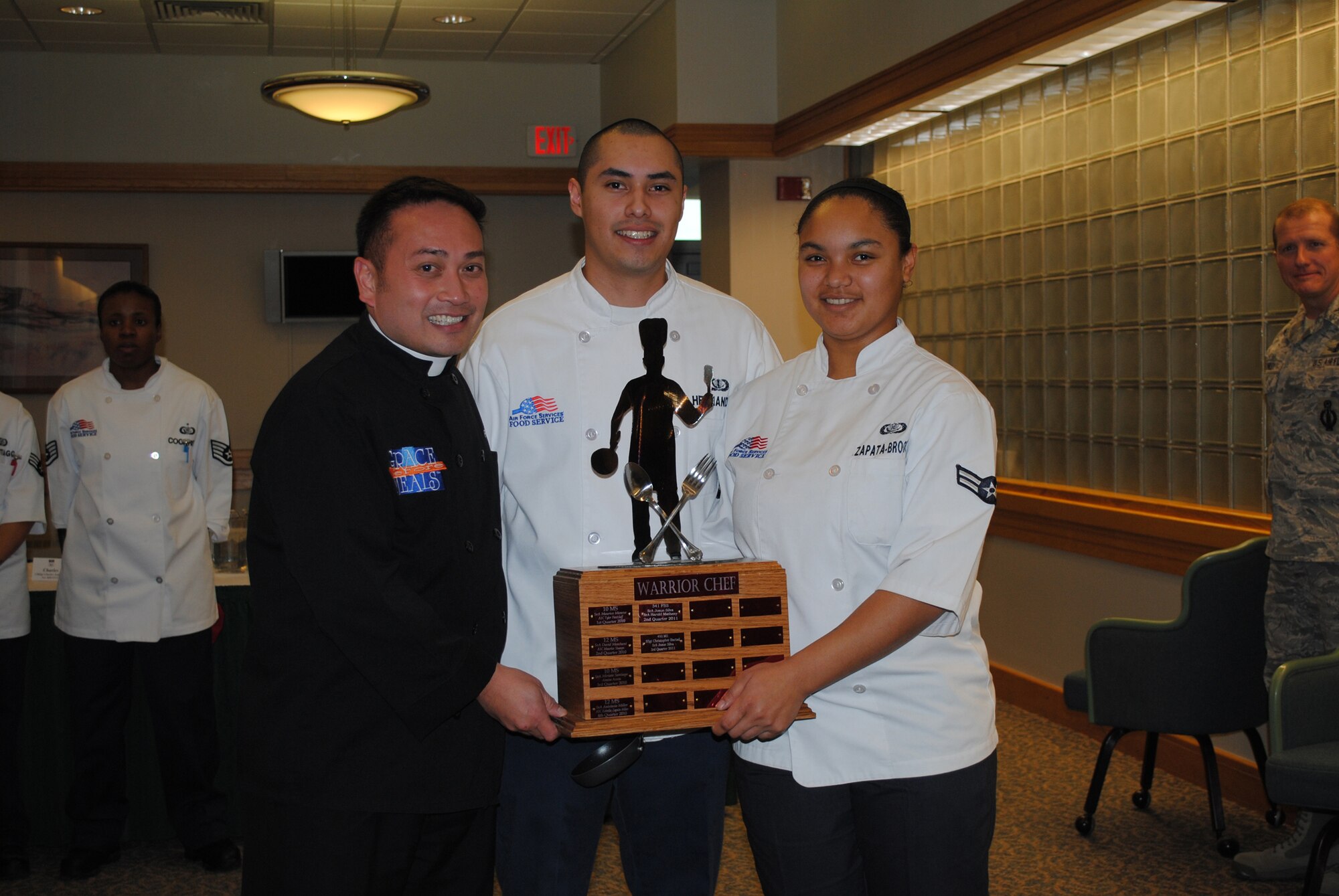 (From left) Father Leo Patalinghug stands with Hernandez and Zapata-Brooks, as they hold the Warrior Chef trophy that will eventually have their names on it for winning the 4th quarter Warrior Chef competition.