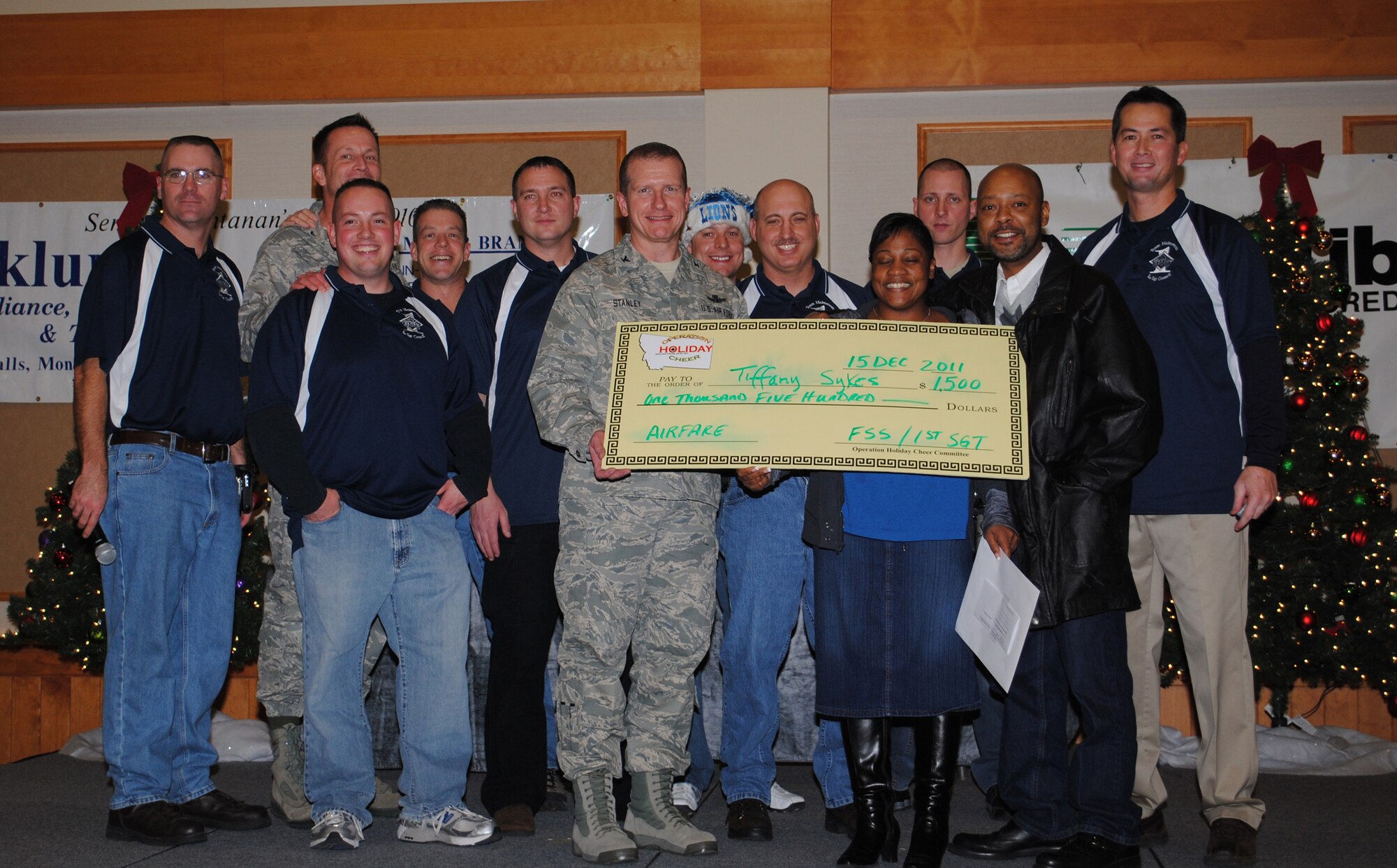 Tech Sgt. Tiffany Sykes, 341st Medical Support Squadron laboratory apprentice, and her husband, Melvin, accept the Operation Holiday Cheer wrap-up party's grand prize of $1,500 towards two round-trip tickets from Col. Robert Stanley, 341st Missile Wing vice commander, Col. Bruce Roehm, 341st Medical Group commander, and Team Malmstrom's Squadron first sergeants.