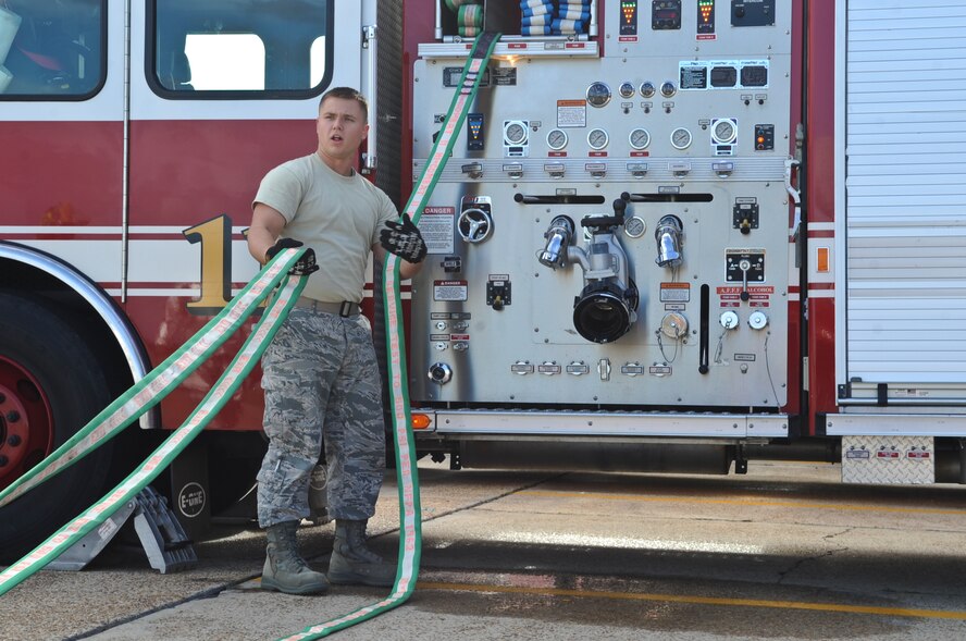 U.S. Air Force Airman 1st Class Elijah Johnson, 23rd Civil Engineer Squadron firefighter, gathers a hose after an exercise at Moody Air Force Base, Ga., Dec. 20, 2011. Firefighters will be working throughout the holiday season and remain prepared for emergency situations. (U.S. Air Force photo by Airman 1st Class Olivia Dominique/Released)