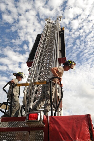 U.S. Air Force Airman 1st Class John Estill, left, and Senior Airman Michael Barnette, 23rd Civil Engineer Squadron firefighters, raise the ladder during an exercise at Moody Air Force Base, Ga., Dec. 20, 2011. Even though they will be on duty through the holiday season, firefighters will be provided dinner and down time to relax. (U.S. Air Force photo by Airman 1st Class Olivia Dominique/Released)