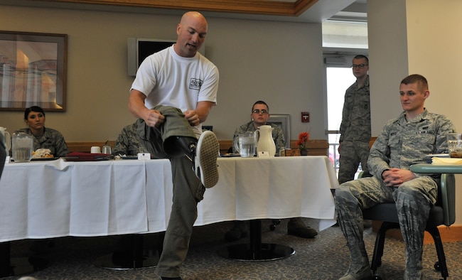 After telling the Airmen attending lunch at the Elkhorn Dining Dec. 15 facility about the circumstances that led to his amputation, Chad Crittenden pulls up his pant leg to expose his prostethic leg. (U.S. Air Force photo/John Turner)