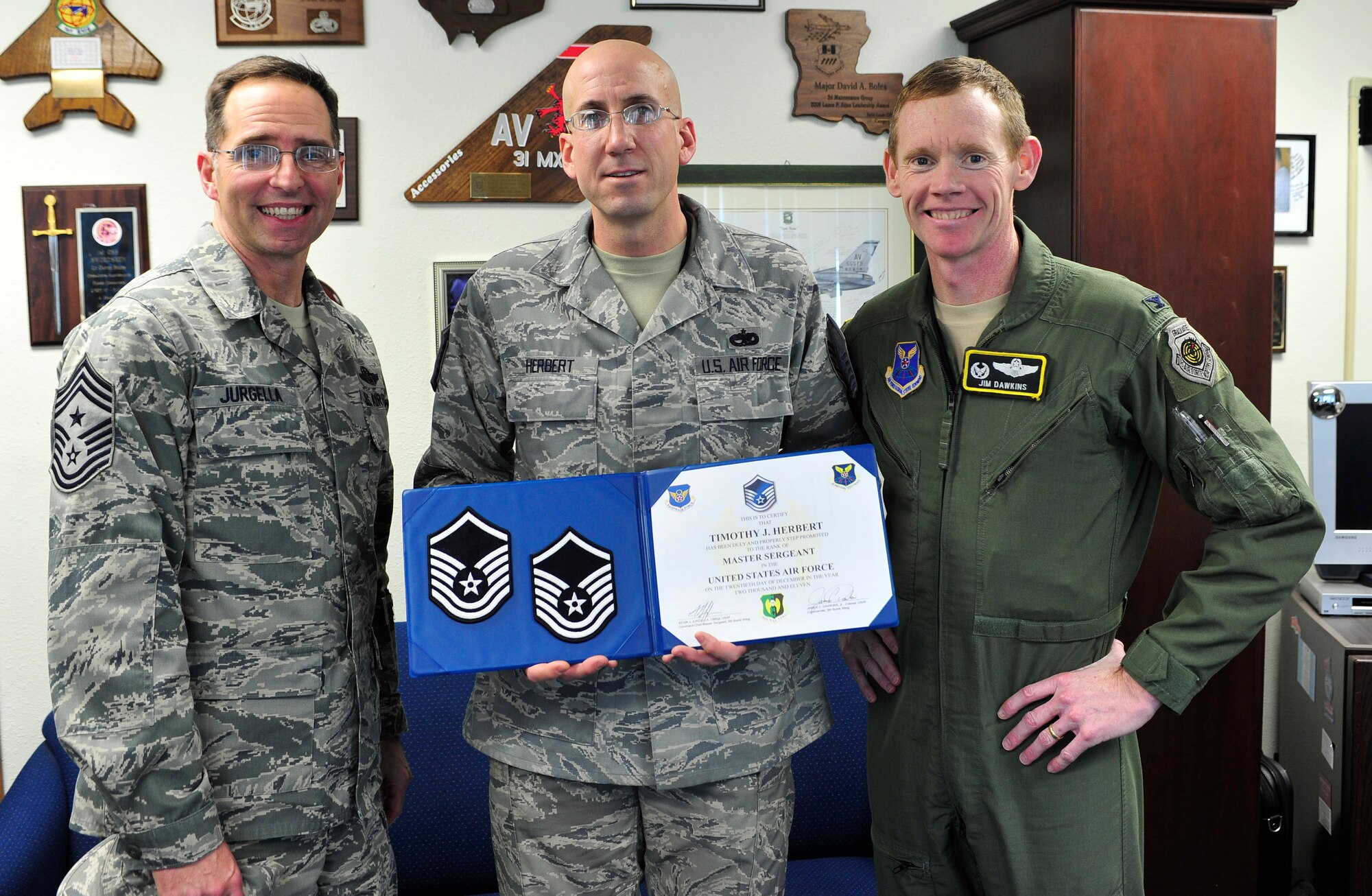 MINOT AIR FORCE BASE, N.D. -- Col. James Dawkins, 5th Bomb Wing commander and Command Chief Master Sgt. Kevin Jurgella, step promotes Tech Sgt. Timothy Herbert, 5th Aircraft Maintenance Squadron, here Dec. 20. (U.S. Air Force photo/Senior Airman Desiree Esposito)