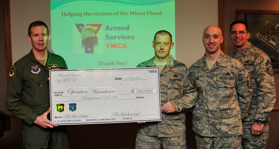 MINOT AIR FORCE BASE, N.D. -- Col. James Dawkins, 5th Bomb Wing commander and Command Chief Master Sgt. Kevin Jurgella, step promotes Tech Sgt. Timothy Herbert, 5th Aircraft Maintenance Squadron, here Dec. 20. (U.S. Air Force photo/Senior Airman Desiree Esposito)