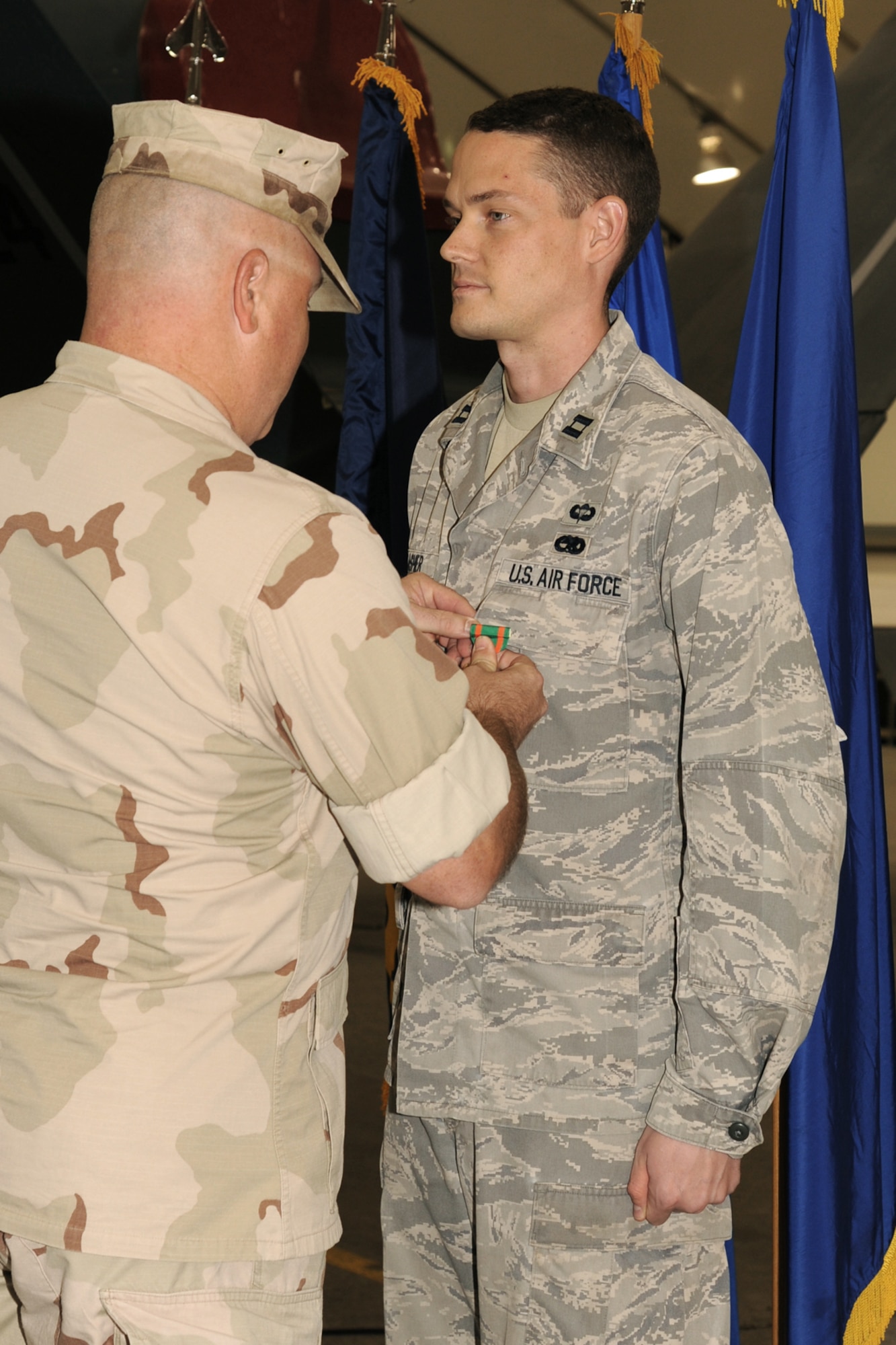 SOUTHWEST ASIA - Capt. Michael Lasher receives a Navy and Marine Corps Achievement Medal from Navy Lt. Cmdr. John McLellan Dec. 27, 2011. According to the citation, his support helped the Navy unit assigned here accomplish a 93 percent mission-completion rate. Lasher has spent the last year assigned to the 380th Air Expeditionary Wing. (U.S. Air Force photo/Tech. Sgt. Arian Nead)