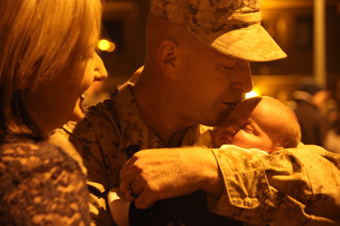 Staff Sgt. Mark Mattson, the radio chief with Marine Wing Communications Squadron 28, kisses his 3-week-old daughter, Lydia, for the first time at the MWCS-28 barracks aboard Marine Corps Air Station Cherry Point Dec. 28 after a six-month deployment to Afghanistan. MWCS-28 deployed to Afghanistan in support of Operation Enduring Freedom.