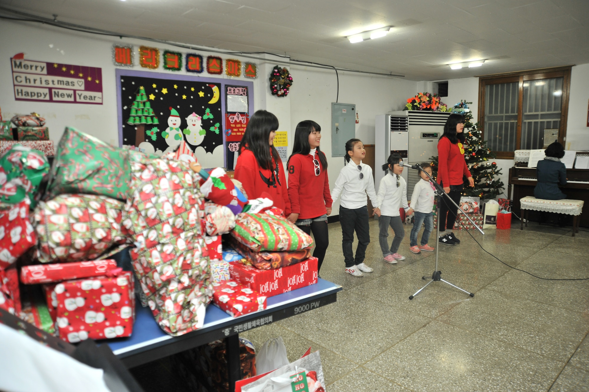 Children from the Samsung Orphanage in Gunsan City, Republic of Korea, perform for the Airmen of the 8th Security Forces Squadron Dec. 22, 2011. Airmen provided each child with three Christmas gifts. The defenders also served dinner and delivered a little Christmas cheer. (U.S. Air Force photo by Senior Airman Brittany Y. Auld/Released)