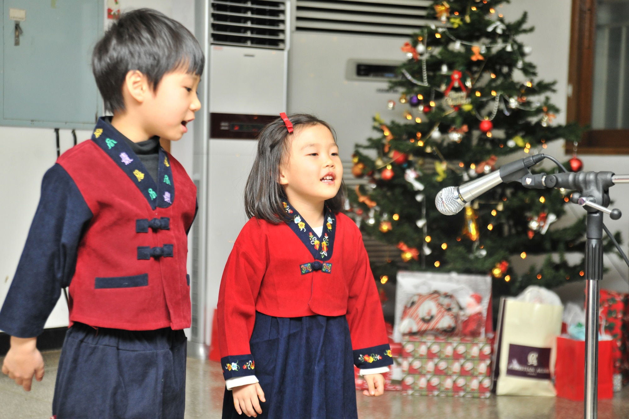 Children from the Samsung Orphanage in Gunsan City, Republic of Korea, perform for the Airmen of the 8th Security Forces Squadron Dec. 22, 2011. Airmen provided each child with three Christmas gifts. The defenders also served dinner and delivered a little Christmas cheer. (U.S. Air Force photo by Senior Airman Brittany Y. Auld/Released)