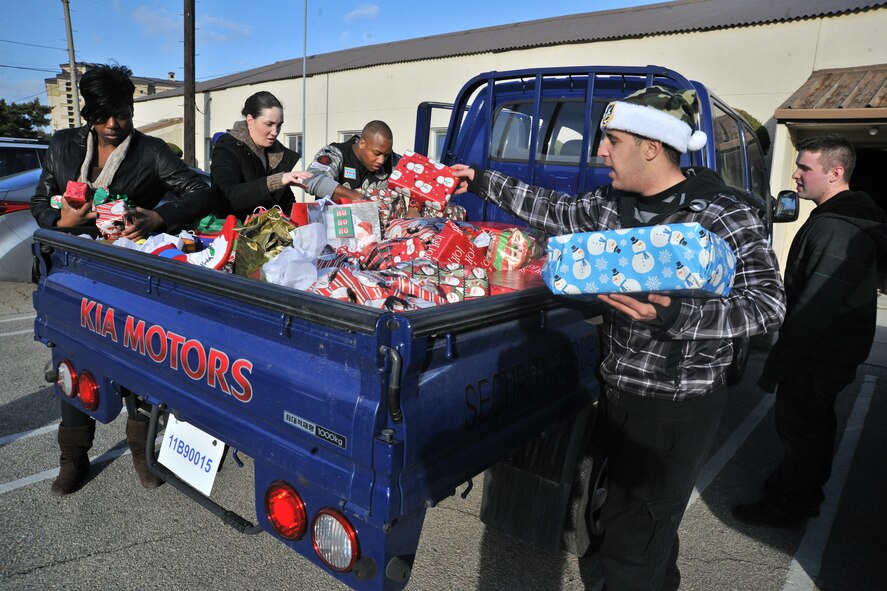 Members of the 8th Security Forces Squadron place Christmas gifts in the back of a vehicle to take to the Samsung Orphanage at Kunsan Air Base, Republic of Korea, Dec. 22, 2011. Airmen provided each child with three Christmas gifts. The defenders also served dinner and delivered a little Christmas cheer. (U.S. Air Force photo by Senior Airman Brittany Y. Auld/Released)