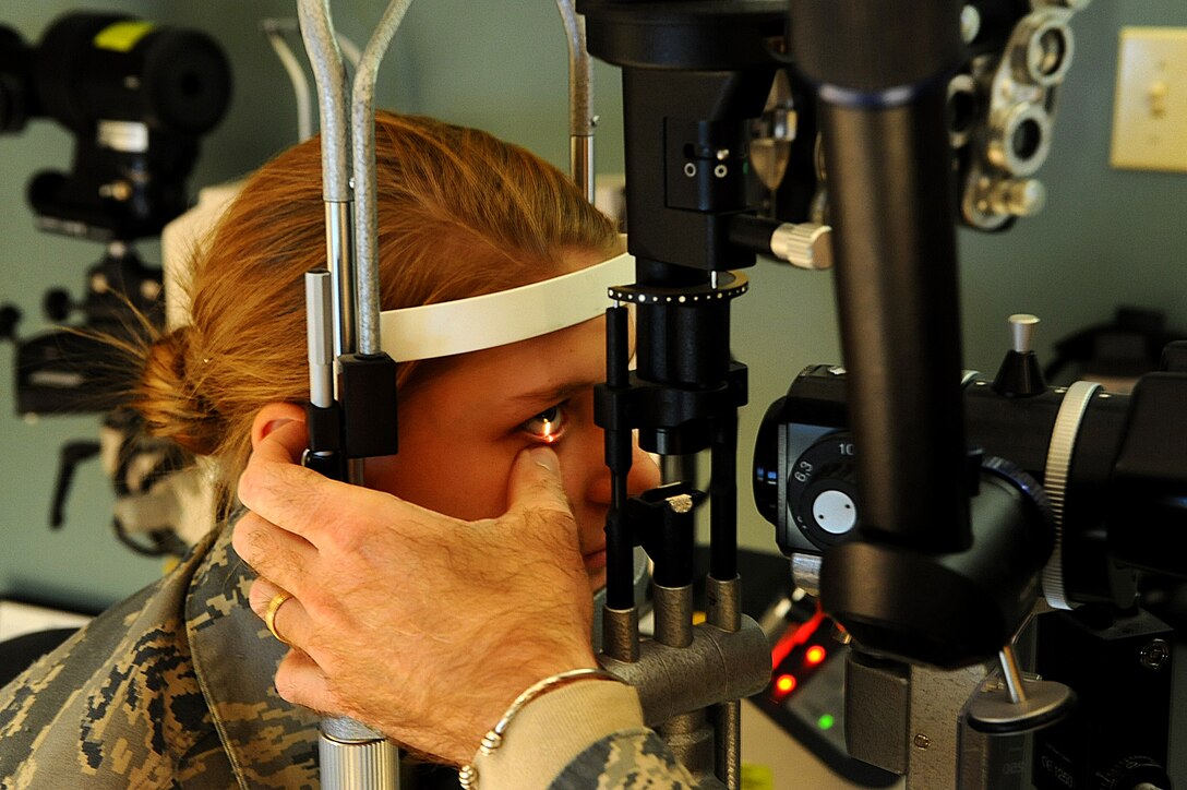Airman 1st Class Nichole Porrini, 28th Security Forces Squadron flight member, has her eyes examined during a health evaluation on Ellsworth Air Force Base, S.D., Dec. 13, 2011. A bio-microscope is used to determine the health of the eyes interior and posterior walls. (U.S. Air Force photo by Airman 1st Class Zachary Hada/Released)