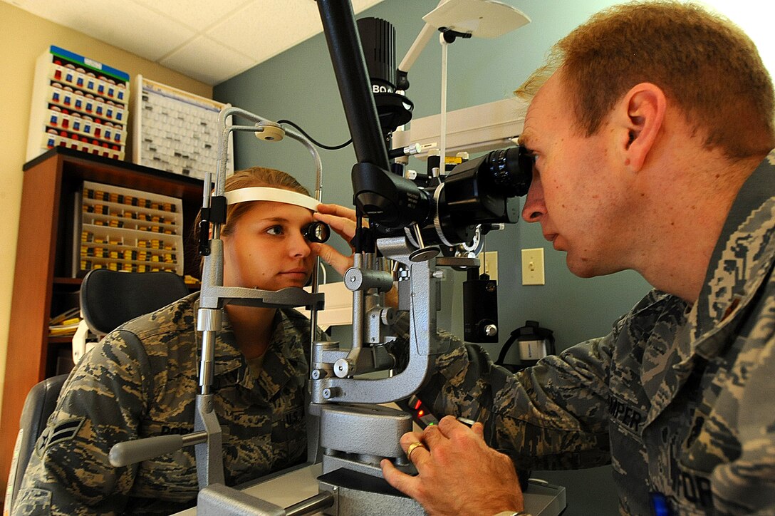 Maj. Bryan Kemper (right), 28th Medical Operations Squadron chief of optometry, uses a bio-microscope to examine Airman 1st Class Nichole Porrini, 28th Security Forces Squadron flight member, during a health evaluation on Ellsworth Air Force Base, S.D., Dec. 13, 2011. Optometrists use bio-microscopes to determine the health of the front and back surfaces of a patient’s eye. (U.S. Air Force photo by Airman 1st Class Zachary Hada/Released)