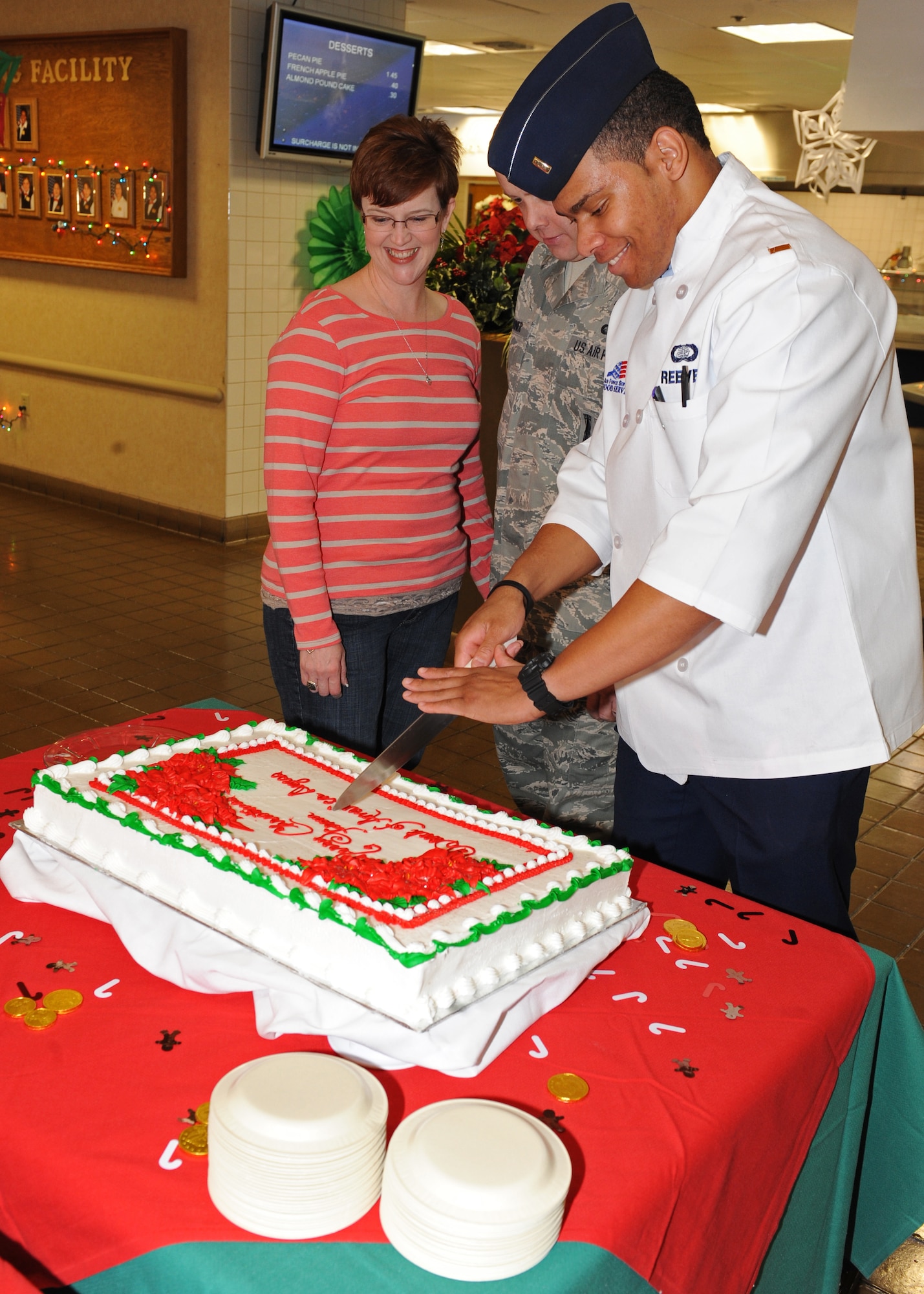 2nd Lt. David Reeves (right), 7th Force Support Squadron, cuts a cake¬¬ Dec. 25, 2011, during the dining facilities’ holiday meal service at Dyess Air Force Base, Texas. First sergeants and commanders helped serve food to airmen who stayed on base for the holidays. (U.S. Air Force photo by Airman 1st Class Peter Thompson/Released)