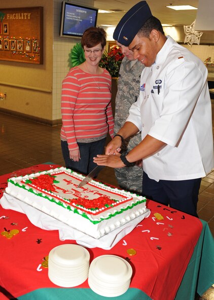 2nd Lt. David Reeves (right), 7th Force Support Squadron, cuts a cake¬¬ Dec. 25, 2011, during the dining facilities’ holiday meal service at Dyess Air Force Base, Texas. First sergeants and commanders helped serve food to airmen who stayed on base for the holidays. (U.S. Air Force photo by Airman 1st Class Peter Thompson/Released)