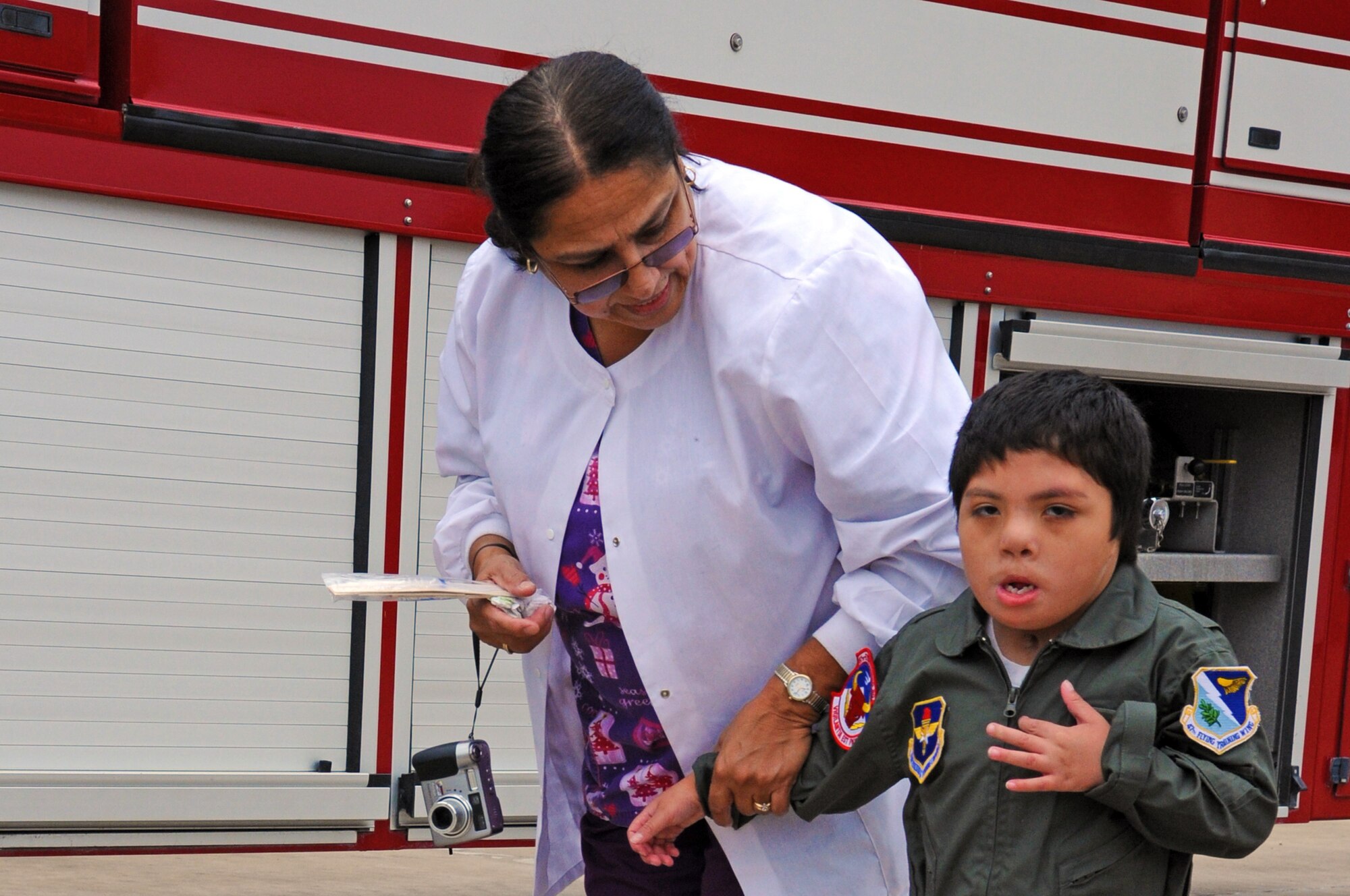 LAUGHLIN AIR FORCE BASE, Texas –Angel Pantino, honorary pilot for a day, walks with his nurse here Dec. 15. Angel was selected for the Pilot for a Day Program which benefit’s children and their families in local communities who have severe illnesses and have a day completely devoted to them. (U.S. Air Force photo/Senior Airman Scott Saldukas)