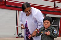 LAUGHLIN AIR FORCE BASE, Texas –Angel Pantino, honorary pilot for a day, walks with his nurse here Dec. 15. Angel was selected for the Pilot for a Day Program which benefit’s children and their families in local communities who have severe illnesses and have a day completely devoted to them. (U.S. Air Force photo/Senior Airman Scott Saldukas)
