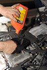 Jerry Cazeault pours engine oil into the engine block after a brake change on Seymour Johnson Air Force Base, N.C., Dec. 27, 2011. A brake change includes brakes pads, rotors and tire rotation. The shop has data information for all vehicles from 1983-2012 so maintenance will be performed correctly. Cazeault is a 4th Force Support Squadron auto skills development mechanic from Woonsocket, R.I. (U.S. Air Force photo by Senior Airman Whitney Stanfield)
